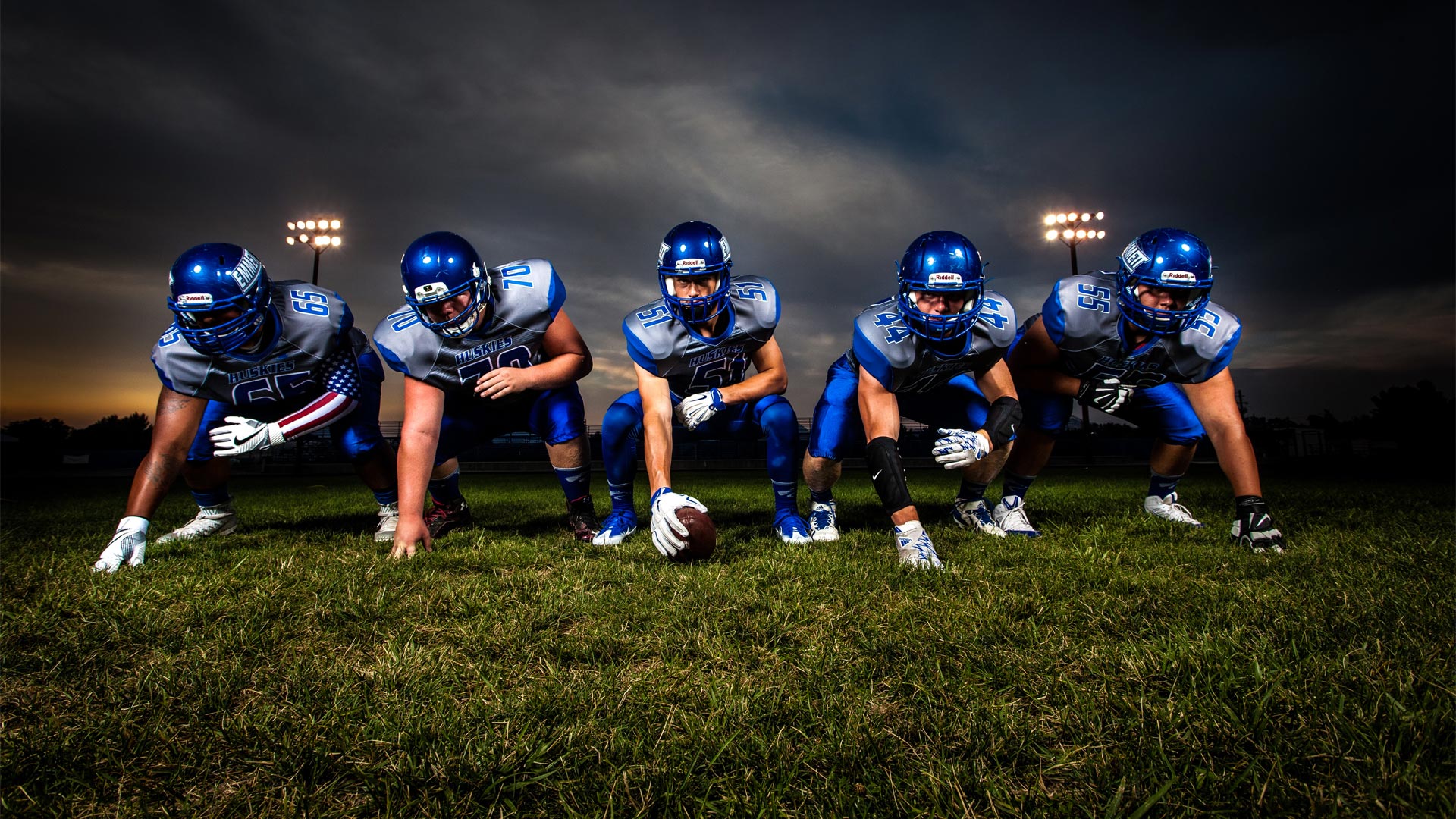 Five football players on field