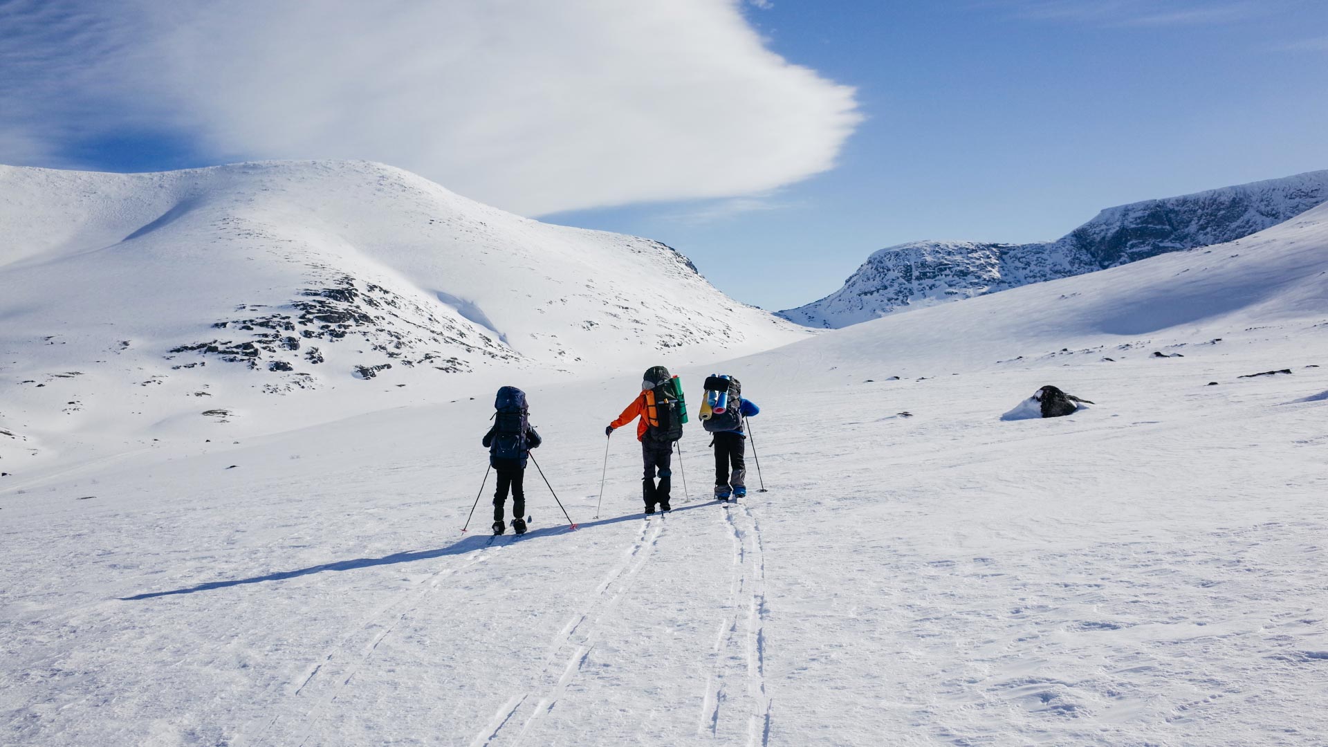 Three people skiing in mountains