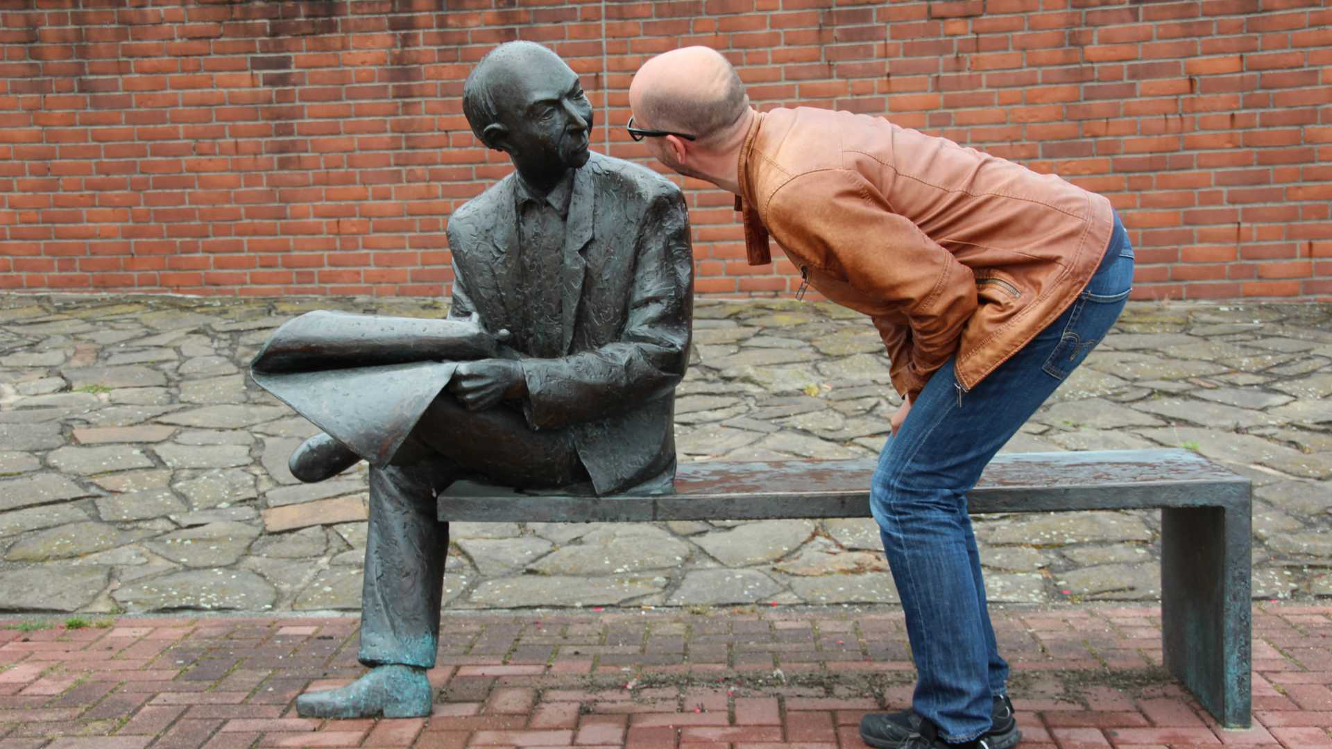 man talking to a statue
