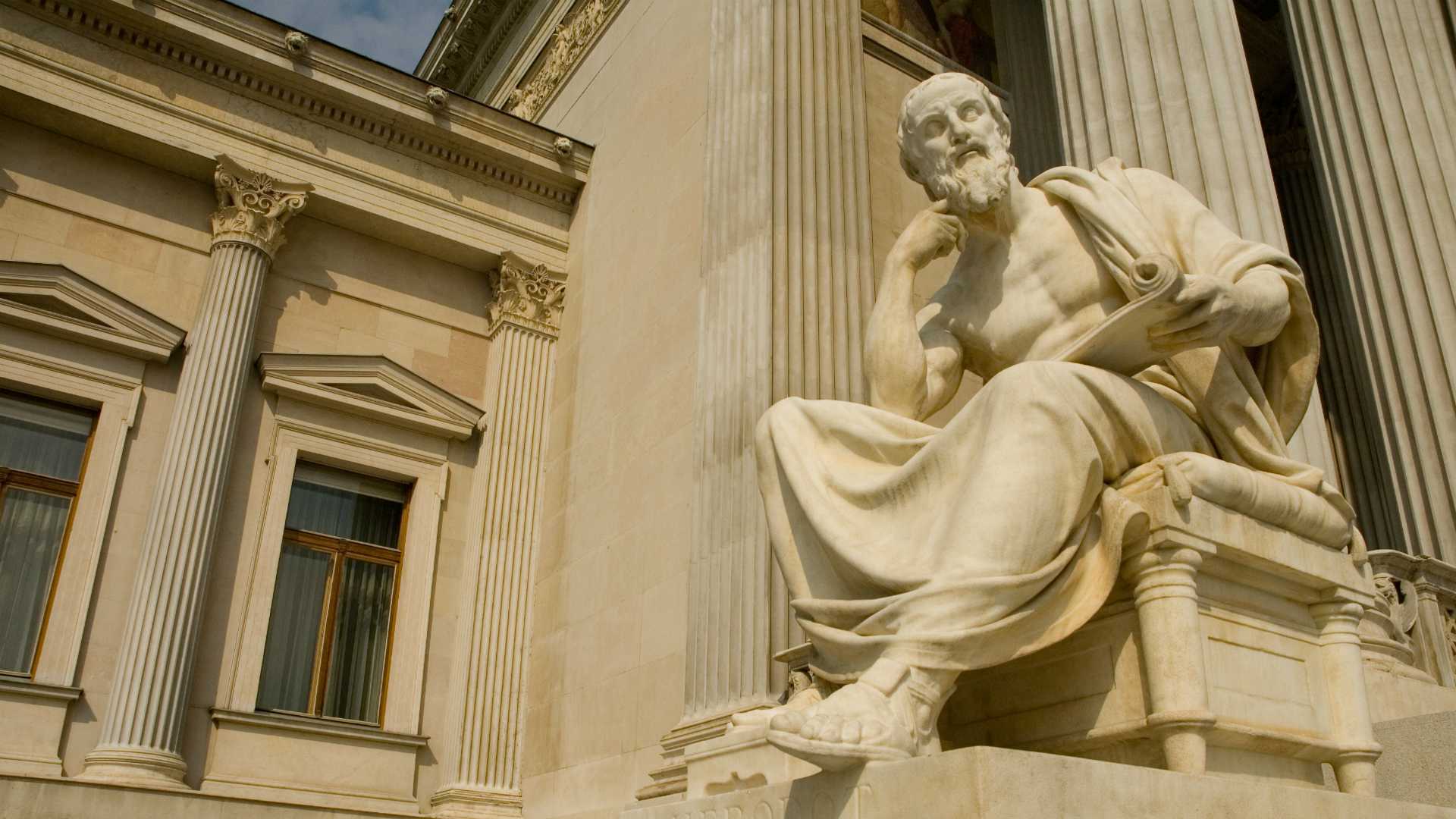 statue of a Greek philosopher in front of a building