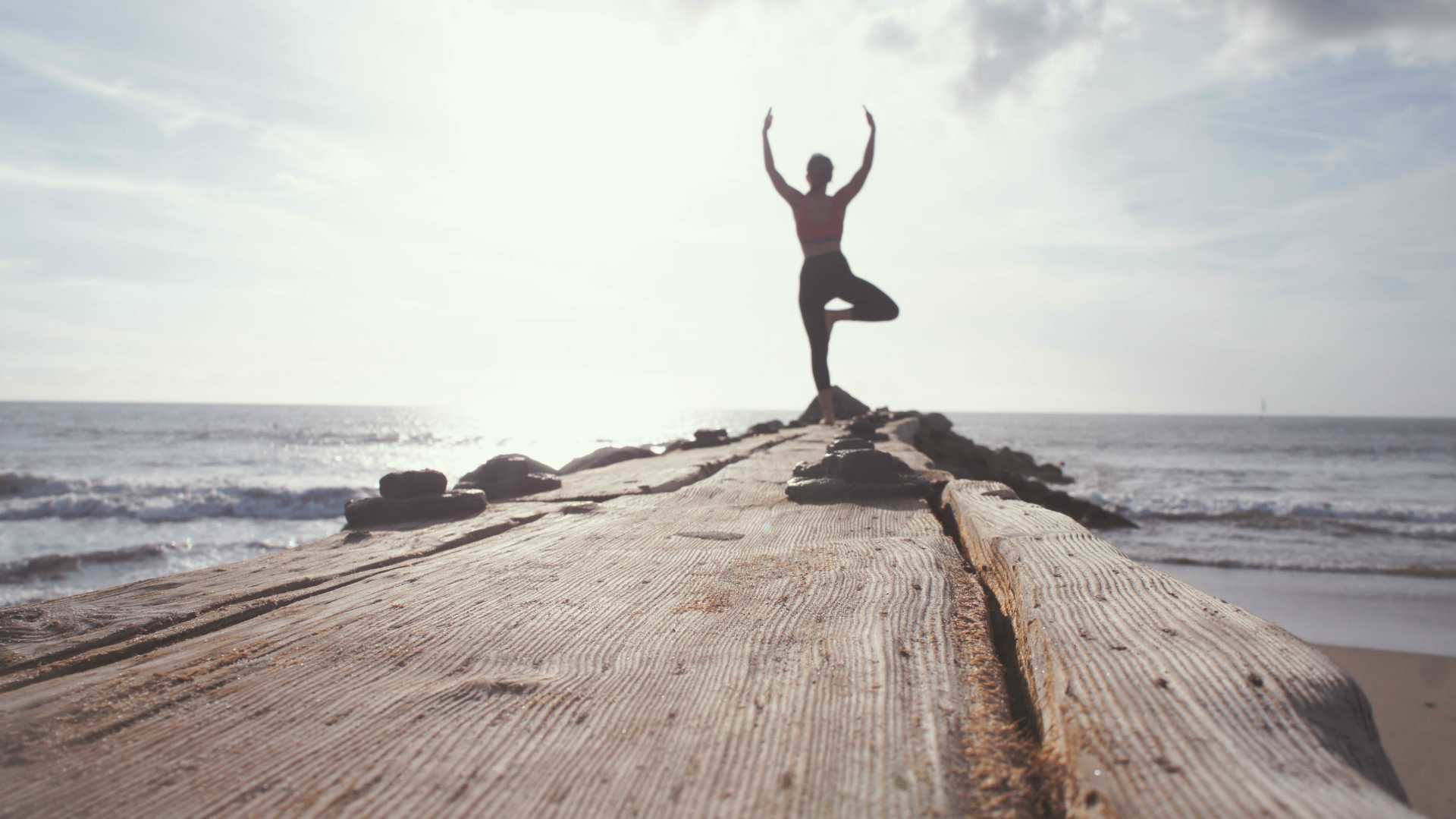 person meditating at the ocean