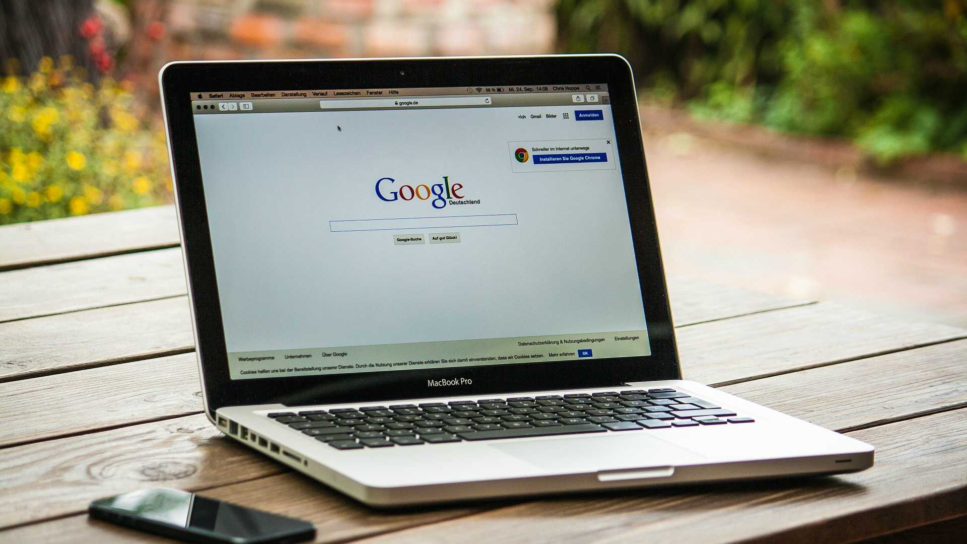 laptop with Google search homepage on a table outside