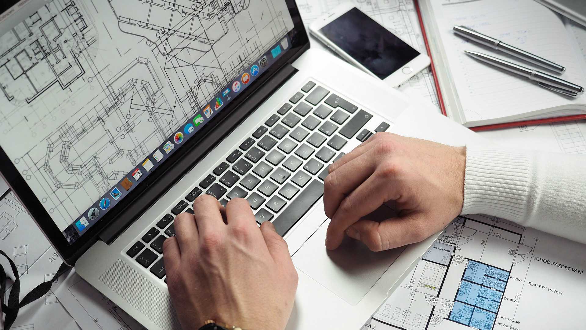 person creating a blueprint on a laptop