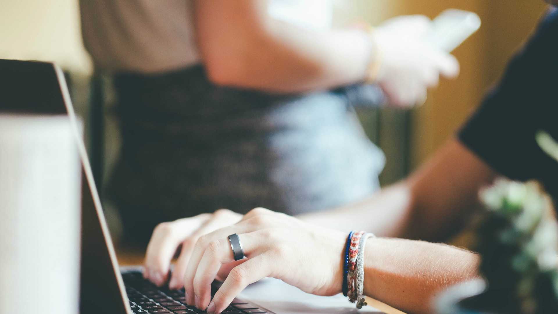 young woman's hands typing on a laptop