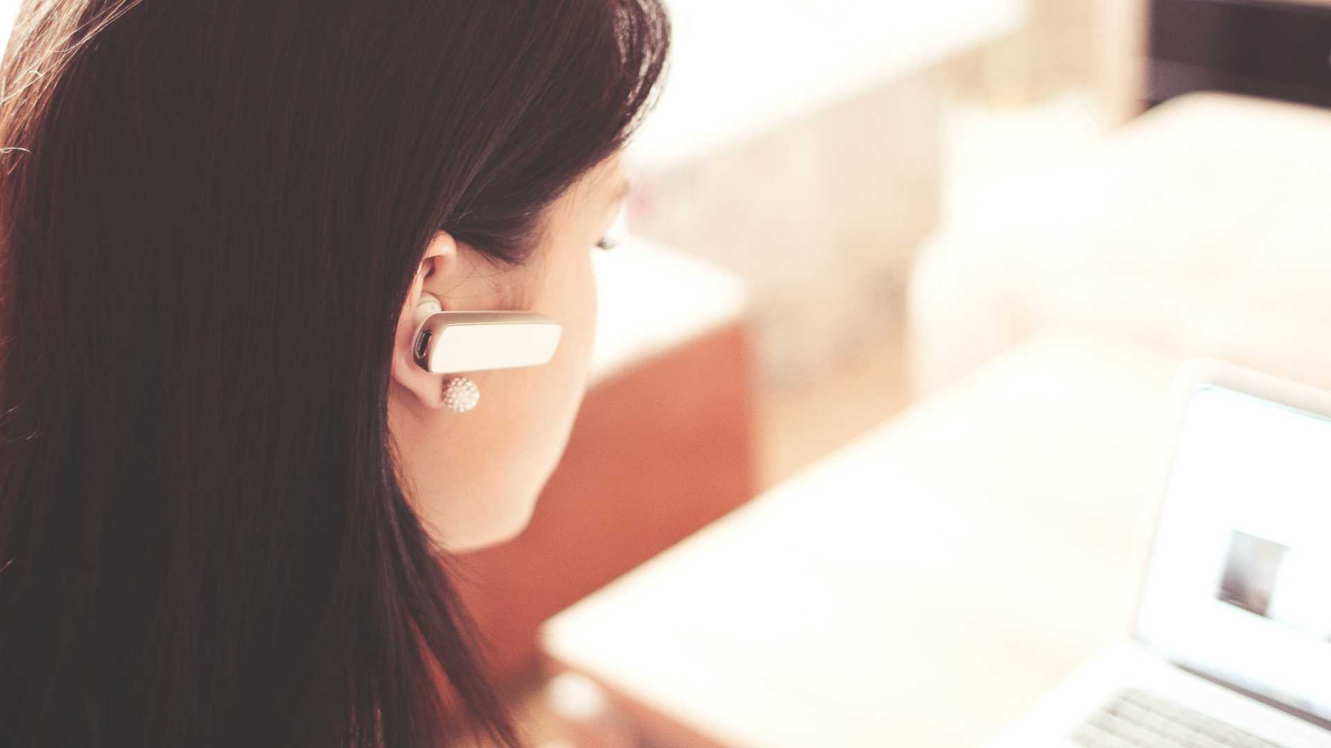woman on a laptop with an earpiece