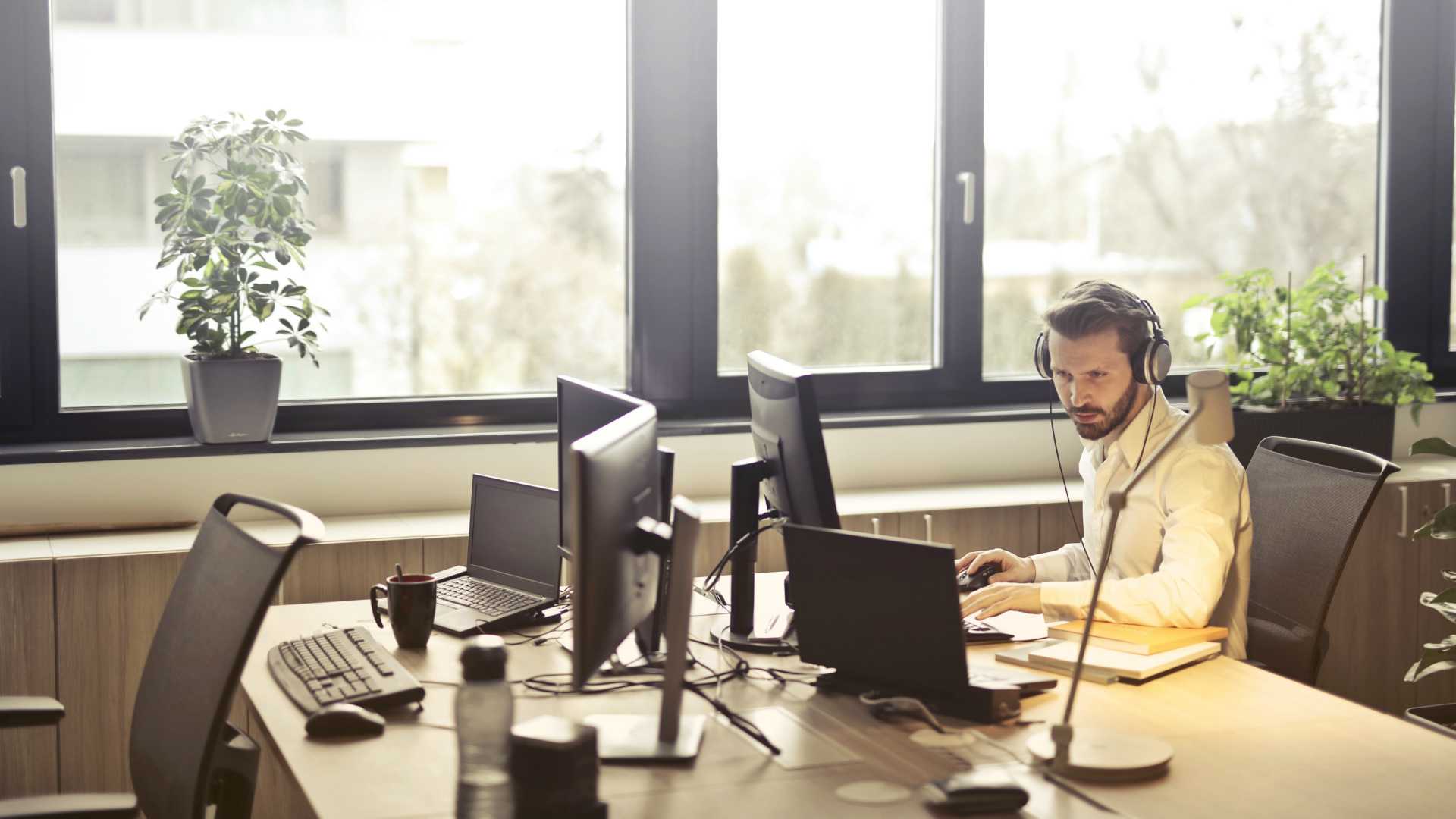 man working with a headset and computers