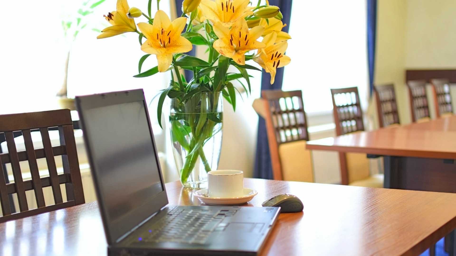 Fresh flowers on a table with a laptop and a cup of coffee