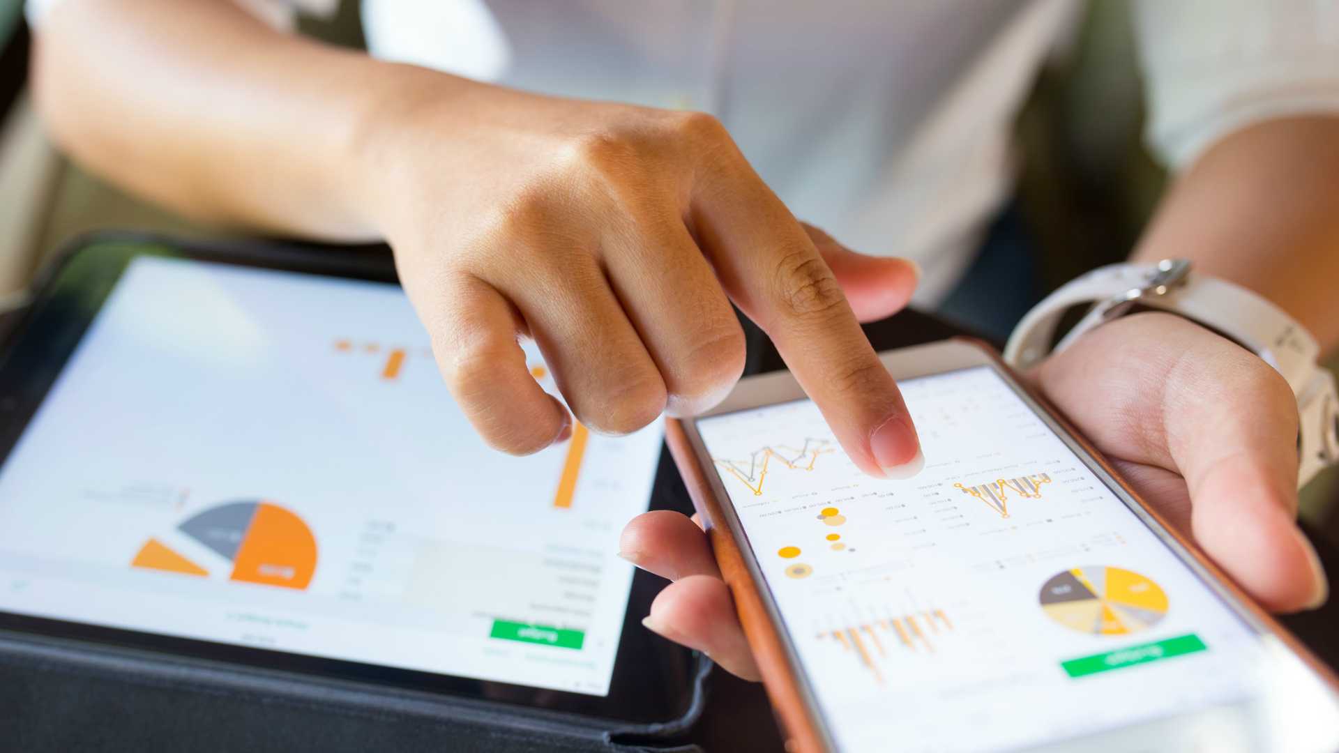 Businesswoman checking data in smartphone and tablet