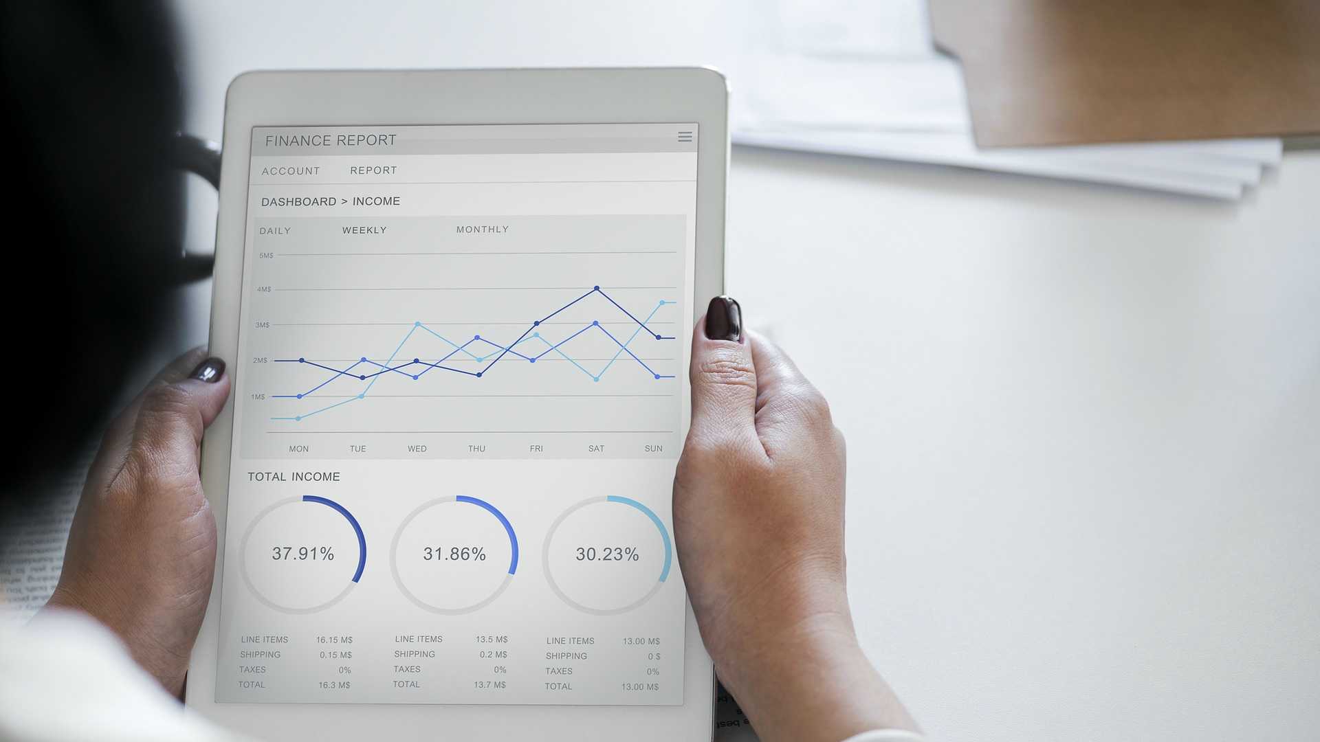 woman holding a tablet with financial information