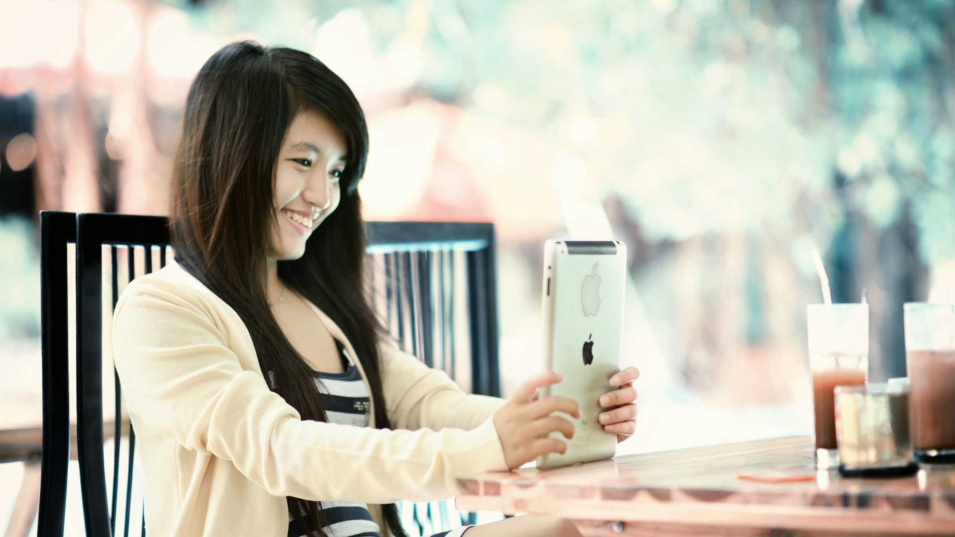 woman smiling into an iPad