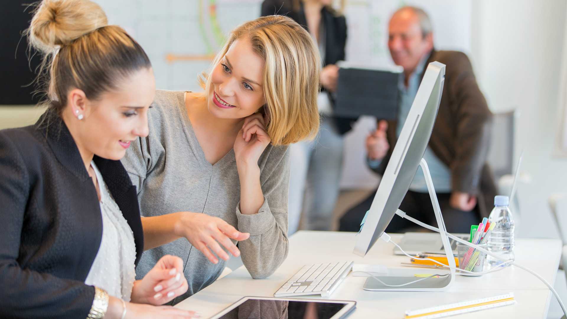 woman helping another woman at work