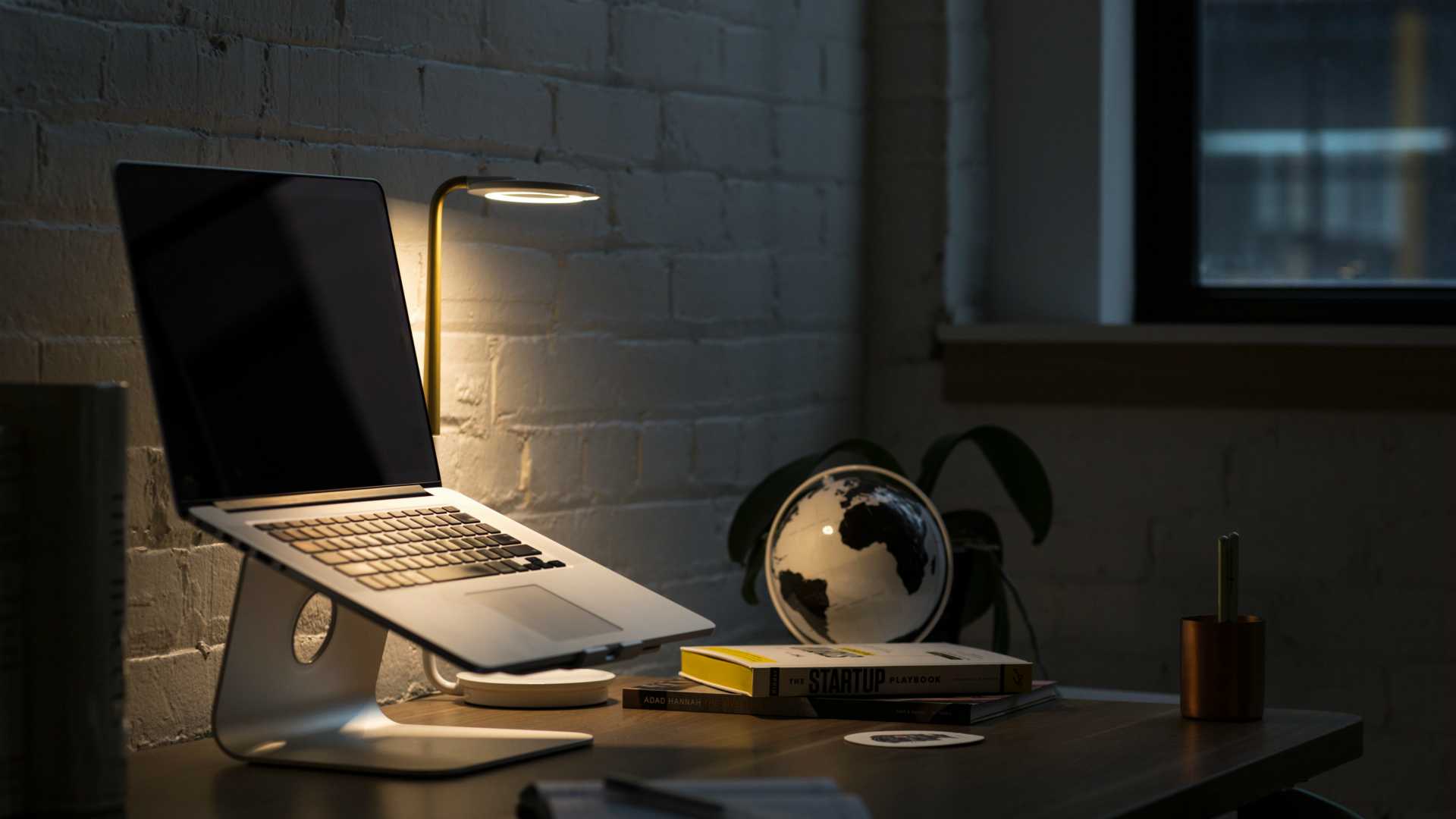 dark office with laptop and globe