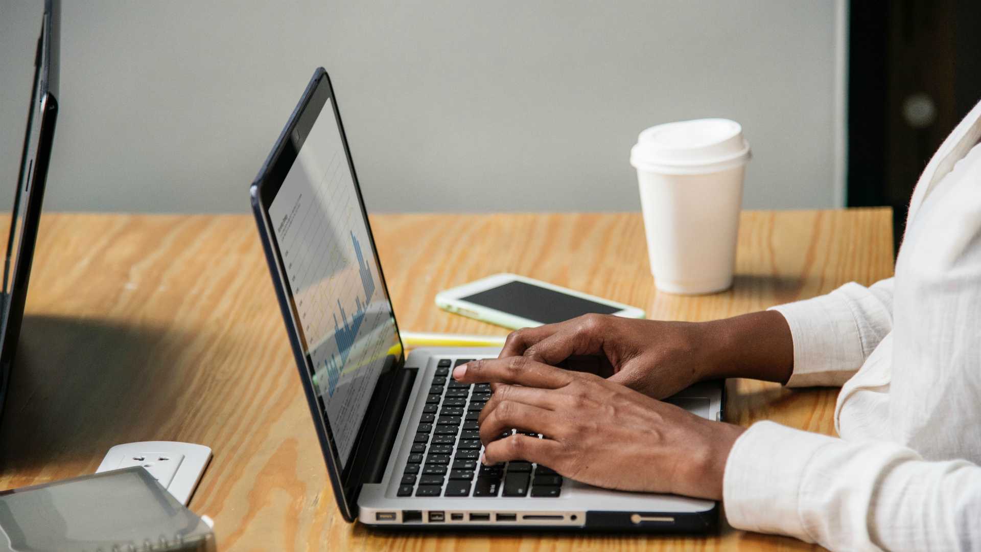 man using a laptop with charts on it