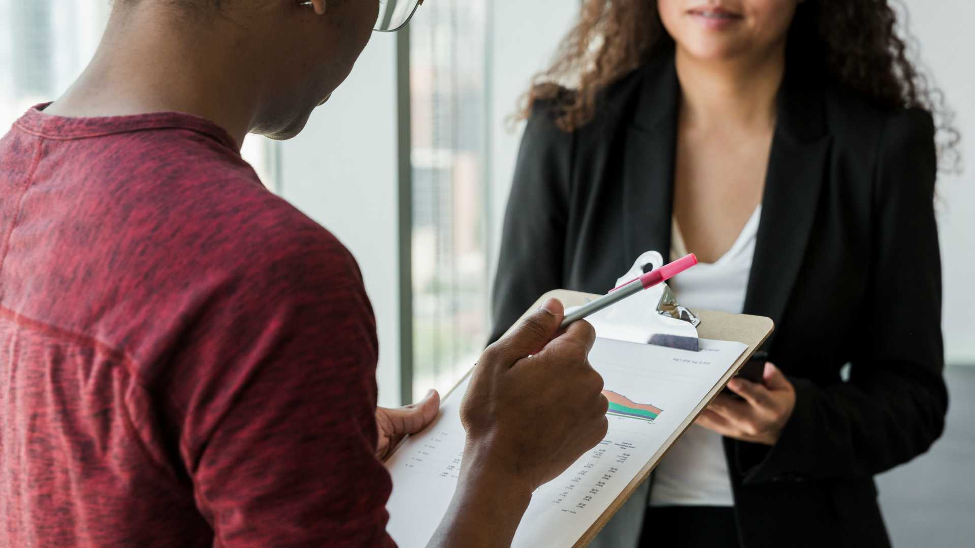 man with checklist talking to woman