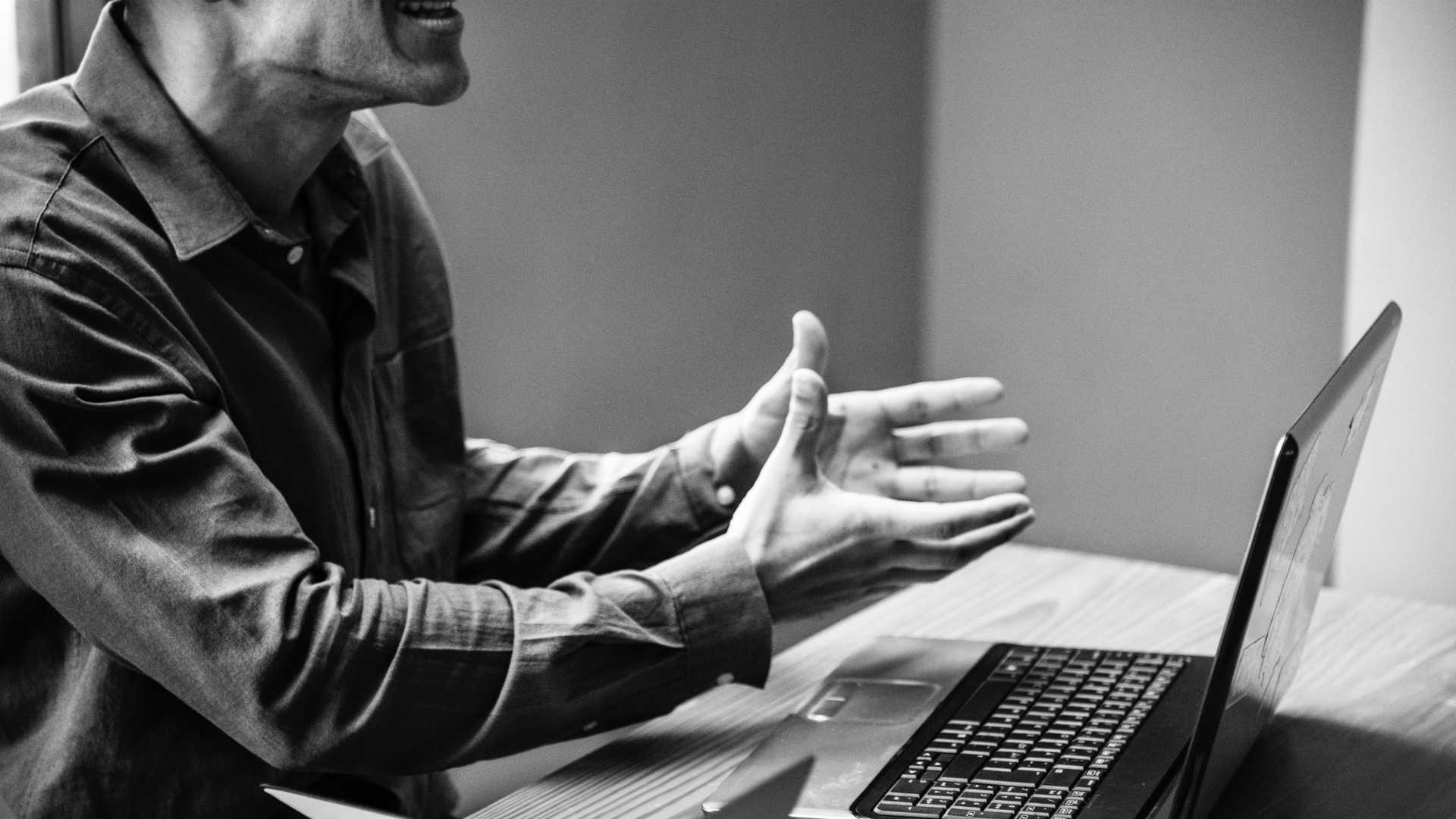 man explaining something in front of a laptop