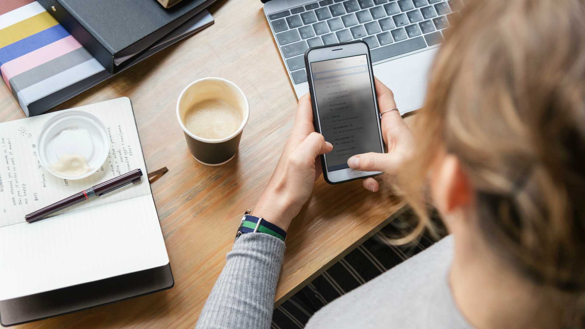 woman checking her phone at her desk