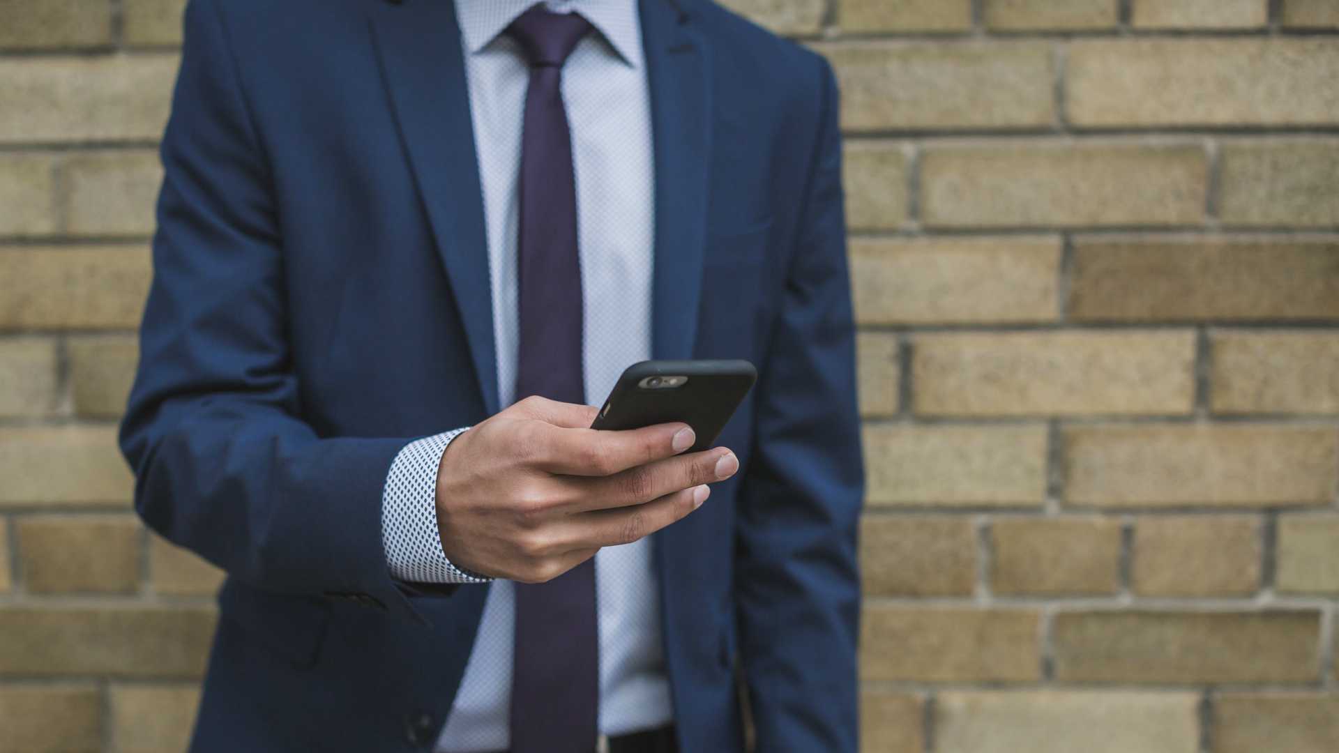 man in suit using a smartphone