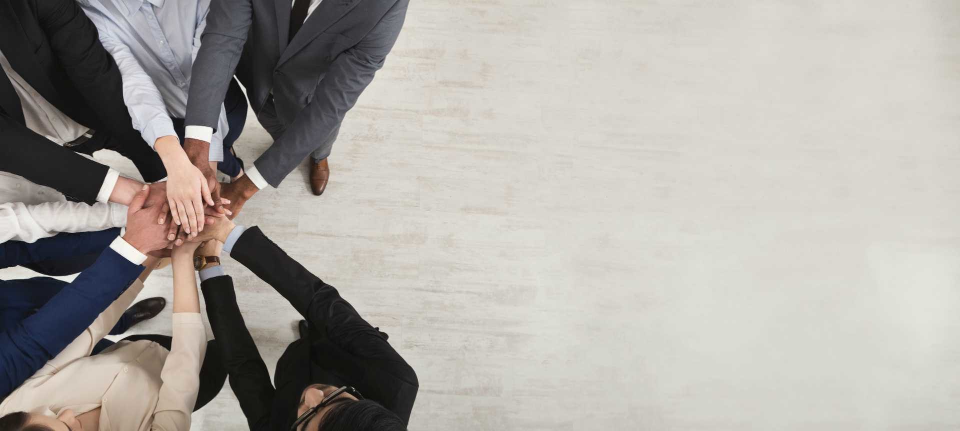 businesspeople "hands in" huddle