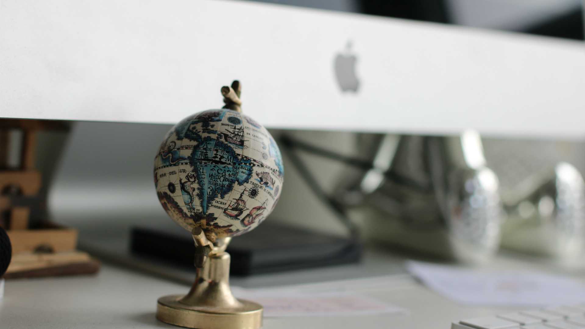 globe on a desk in front of a computer