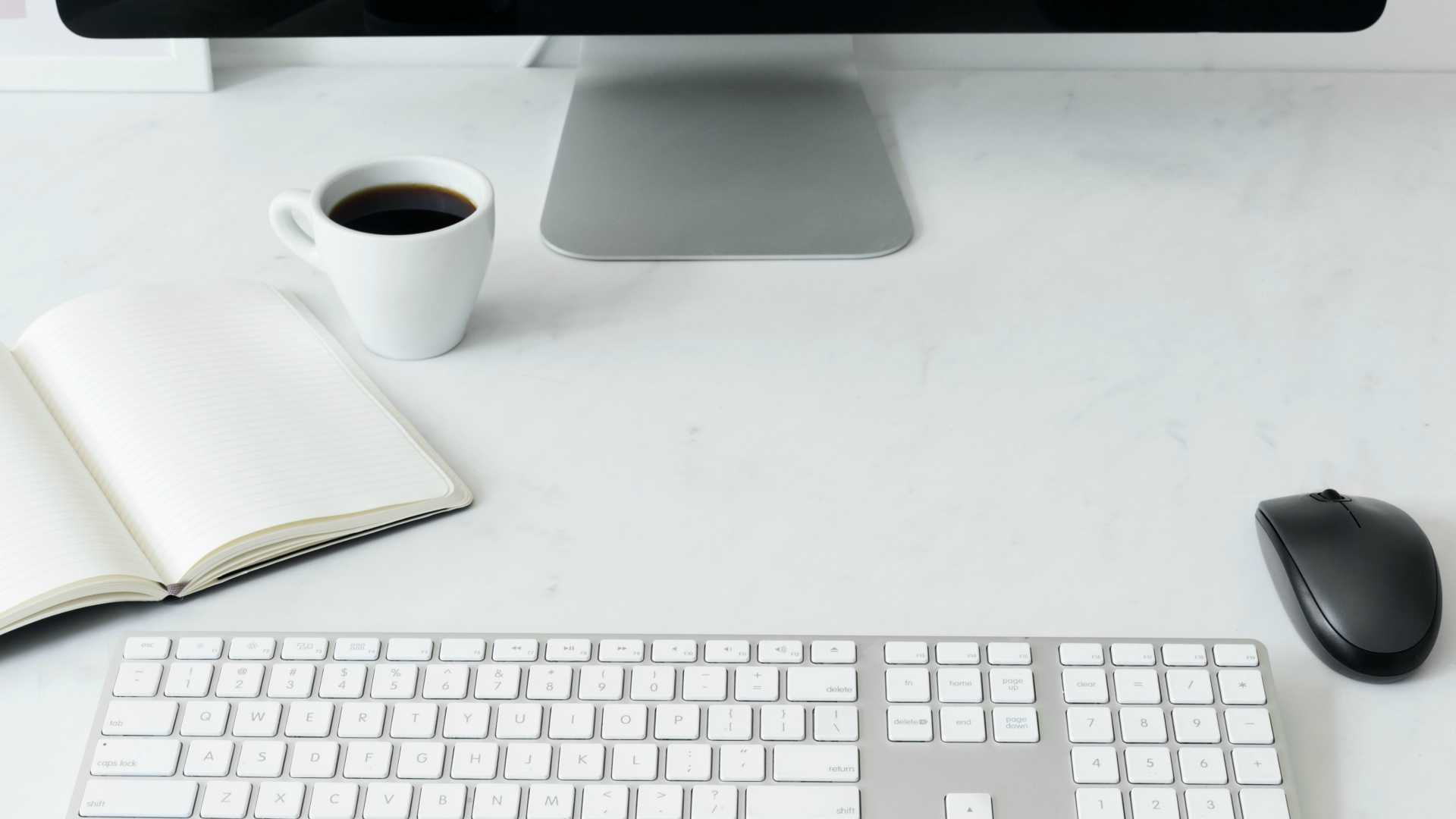 computer with notebook and cup of coffee