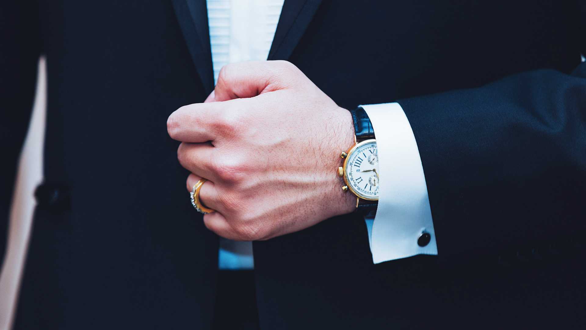 man's hand pulling his blazer shut