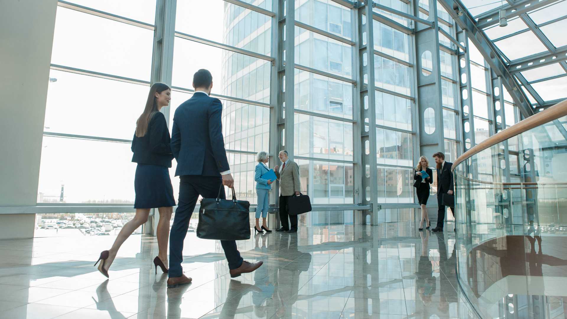 businesspeople walking in a large glass building
