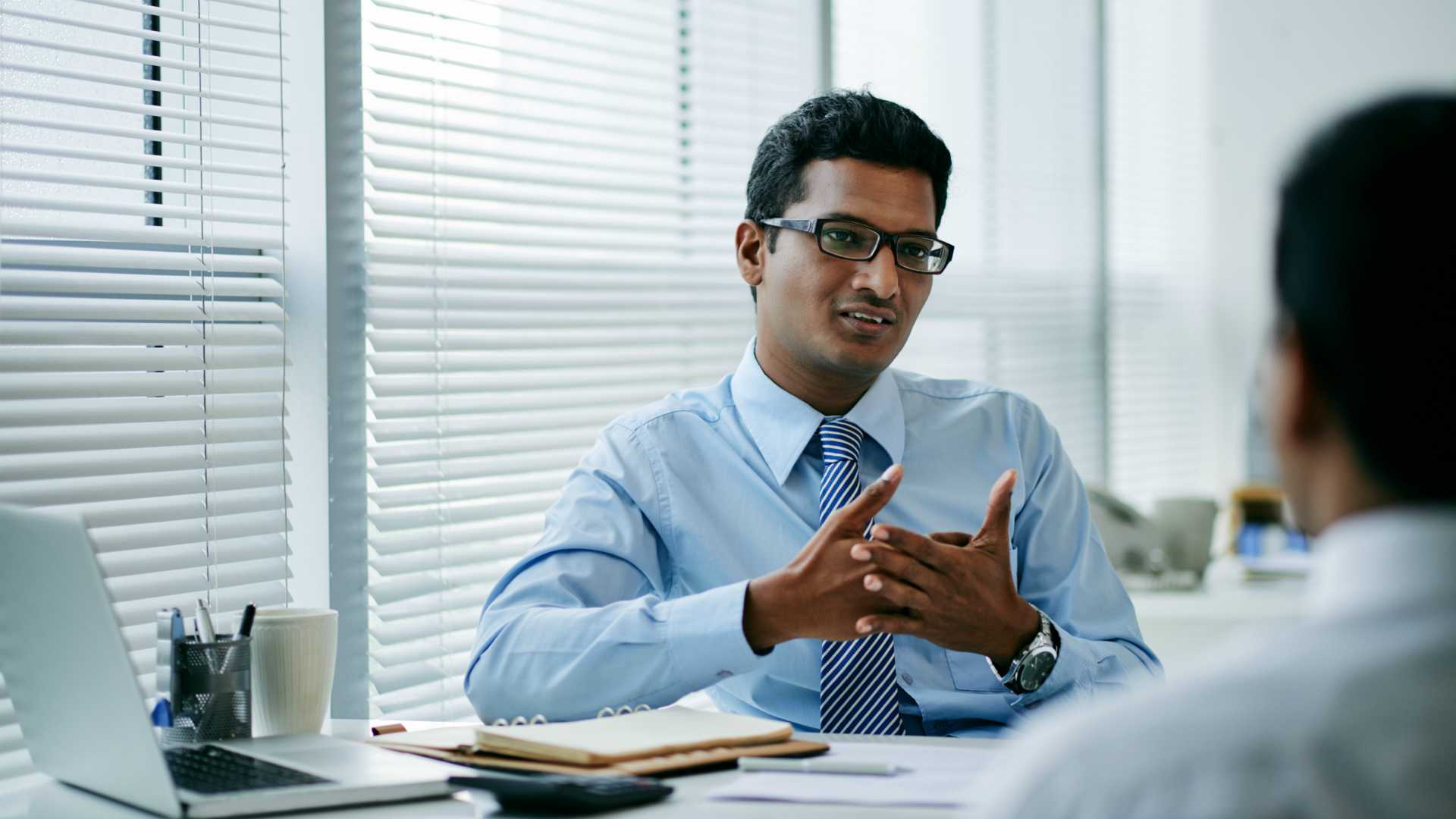 Businessman talking to a colleague or employee in his office