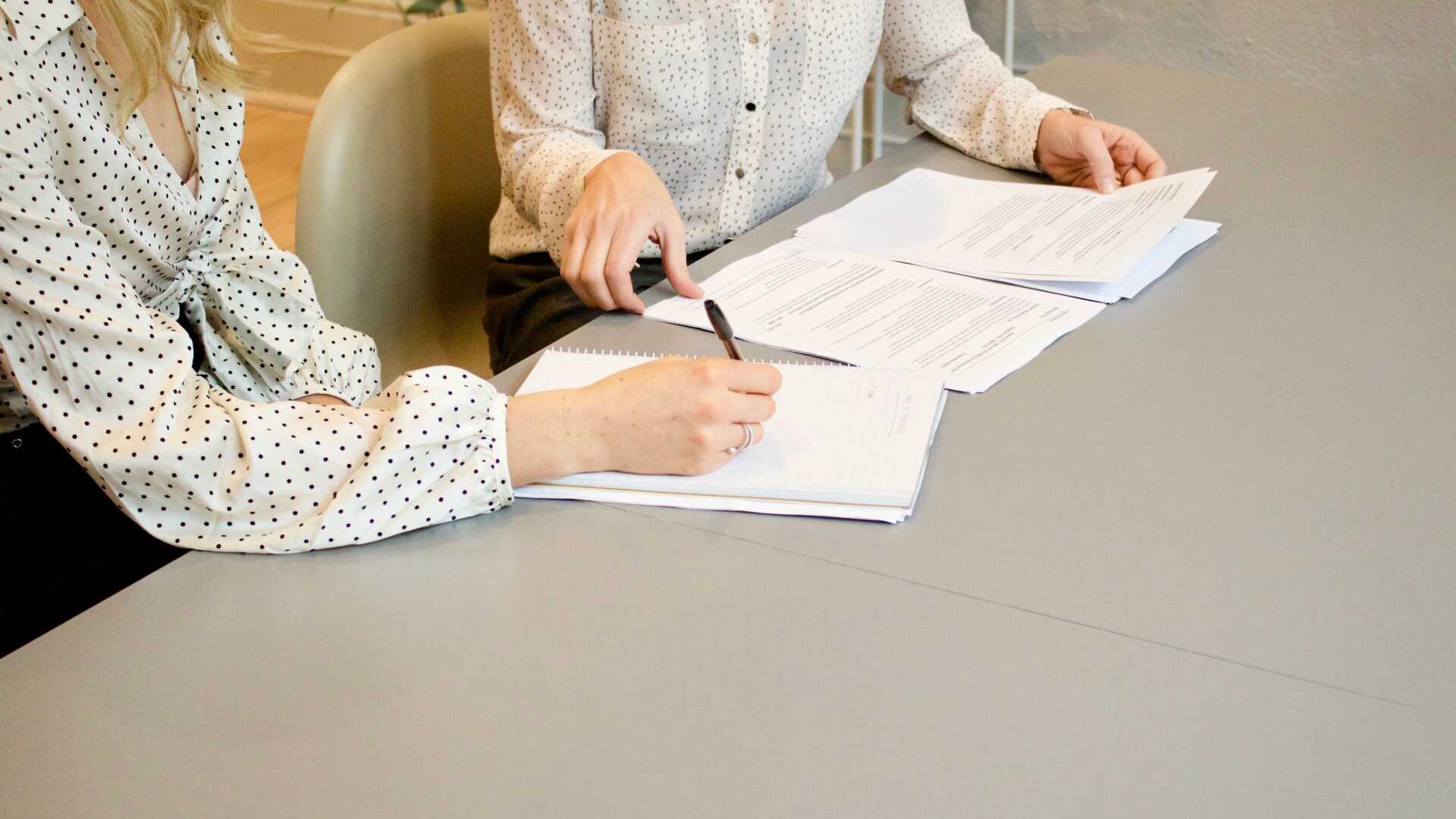 two businesswomen reviewing papers