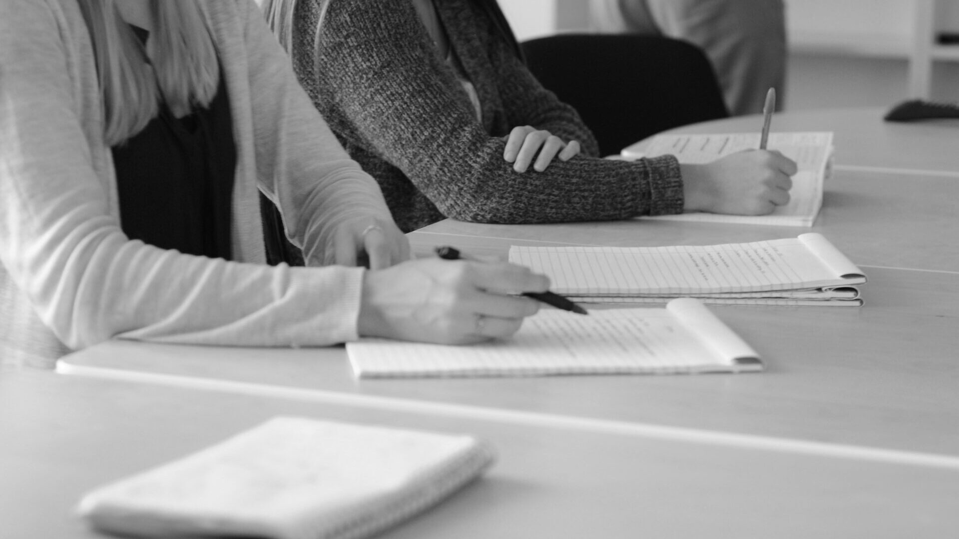 Black and white photo of employees working at conference table