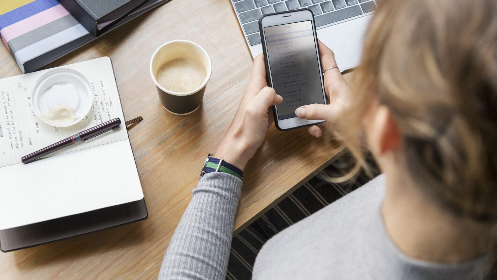 Woman sitting at desk and typing on smartphone