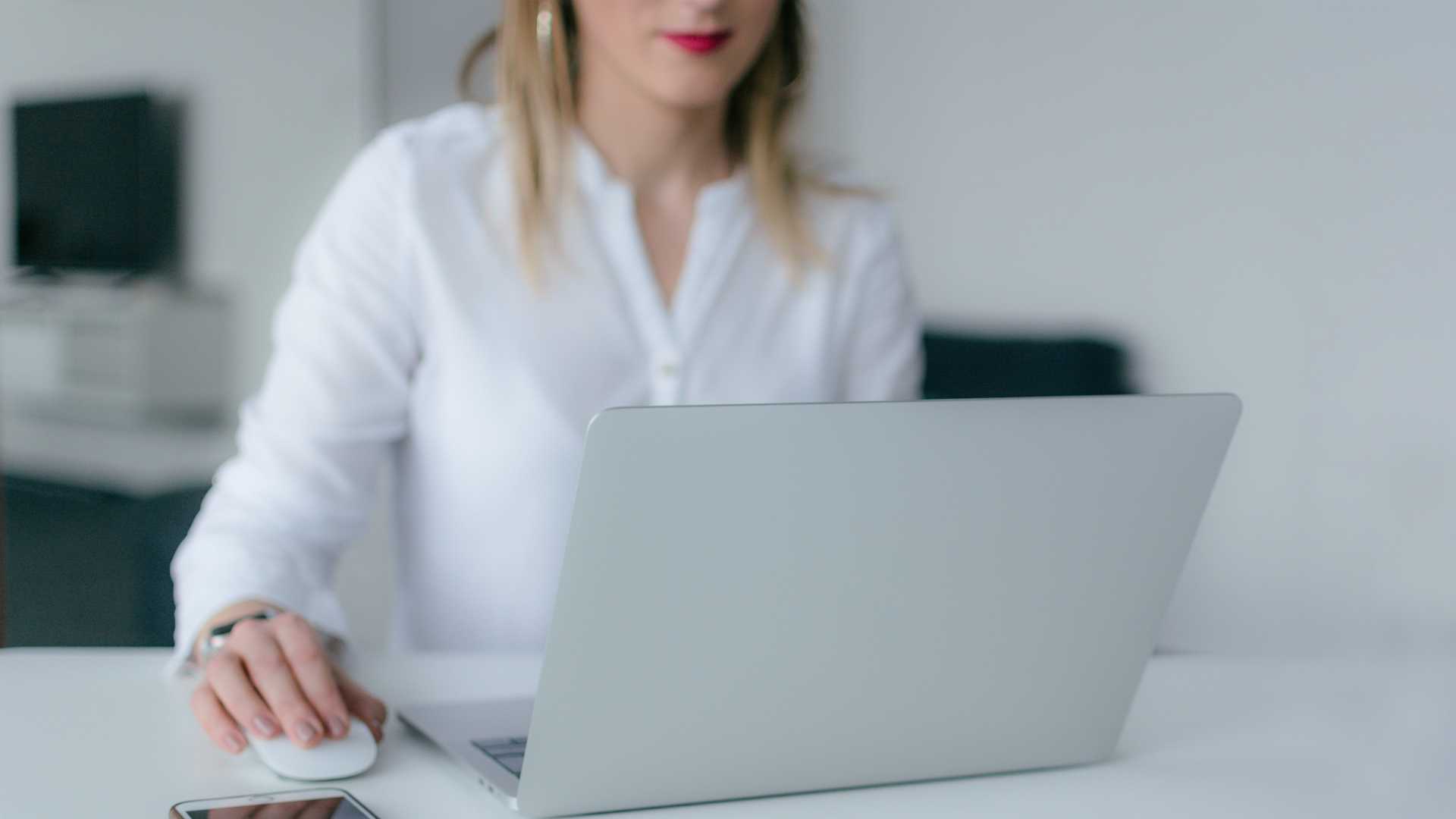 Businesswoman working on laptop in white office