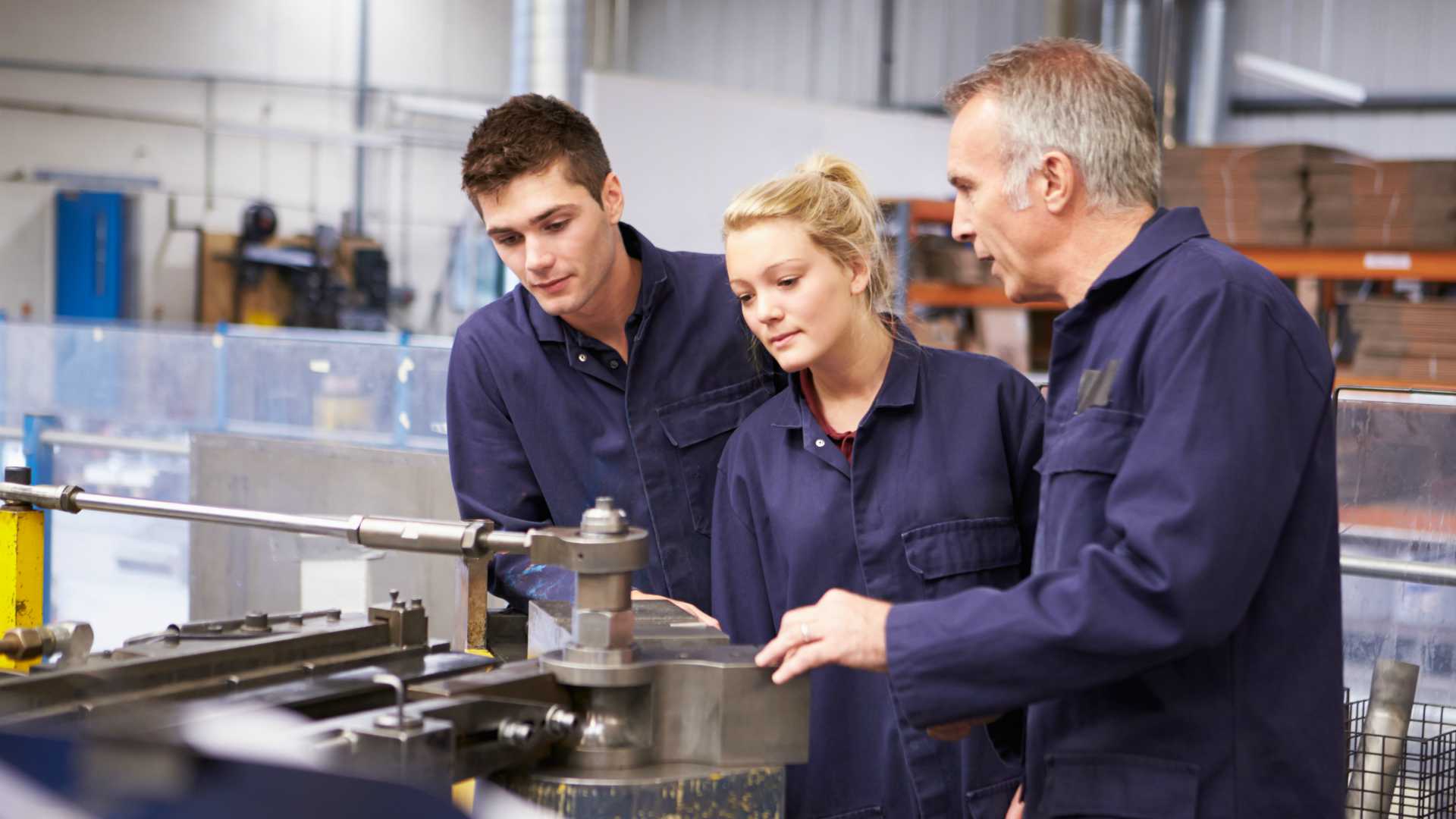 Assembly and operation trainer instructing young male and young female employees on how to use equipment