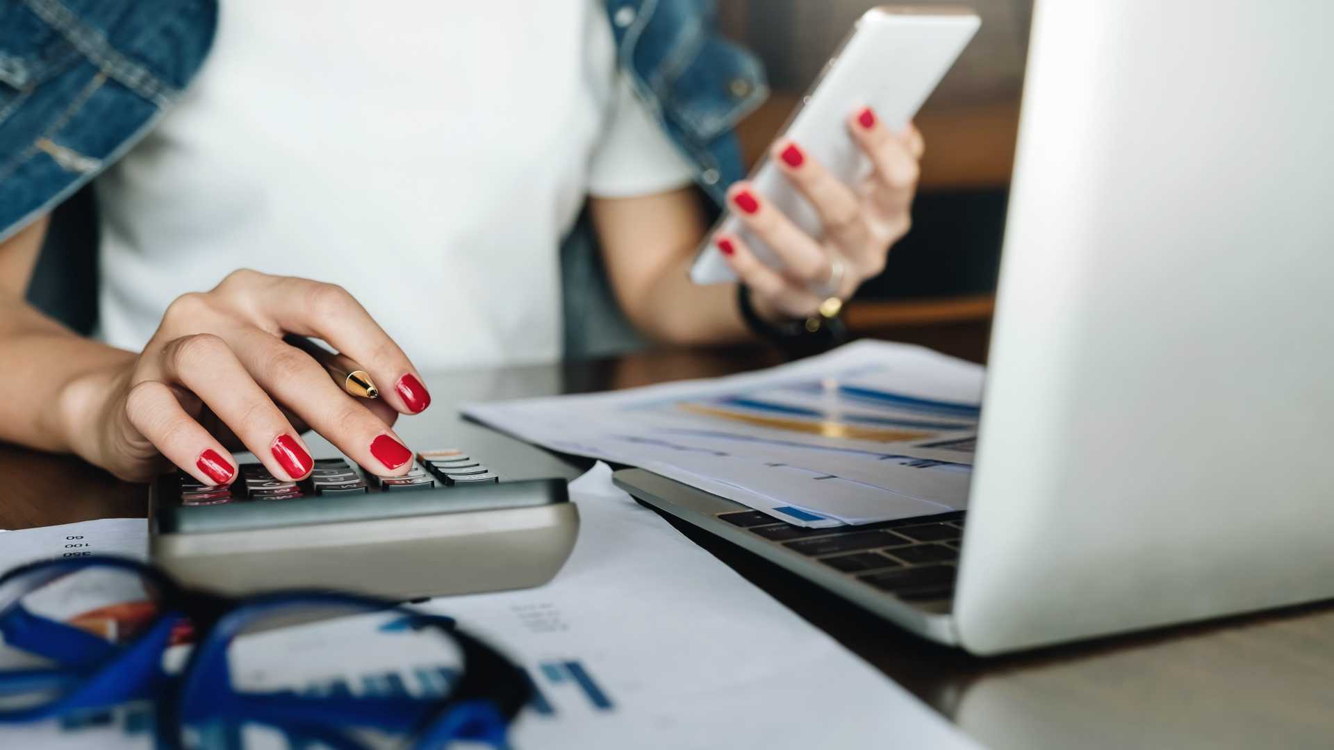 businessman working with calculator and digital tablet computer with financial business strategy layer effect in office, bookkeeper and auditor concept.