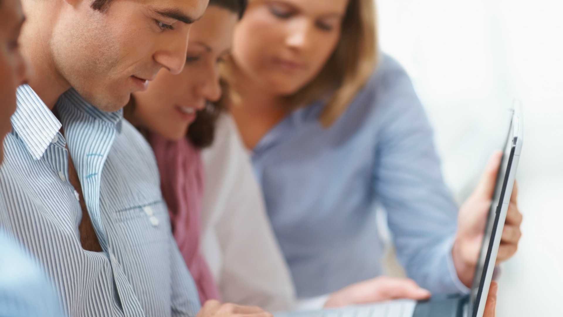 Group of business colleagues working together on a laptop