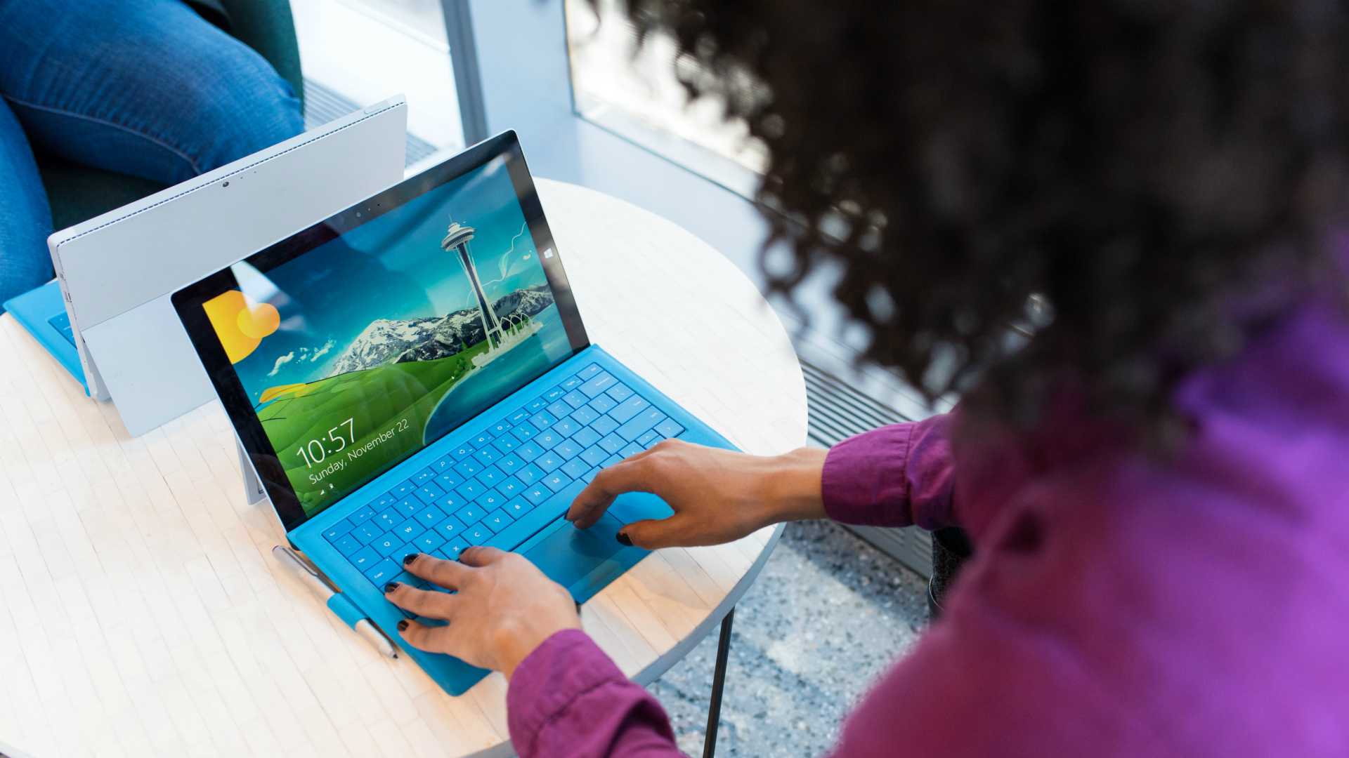 Businesswoman working at desk on laptop with blue keyboard