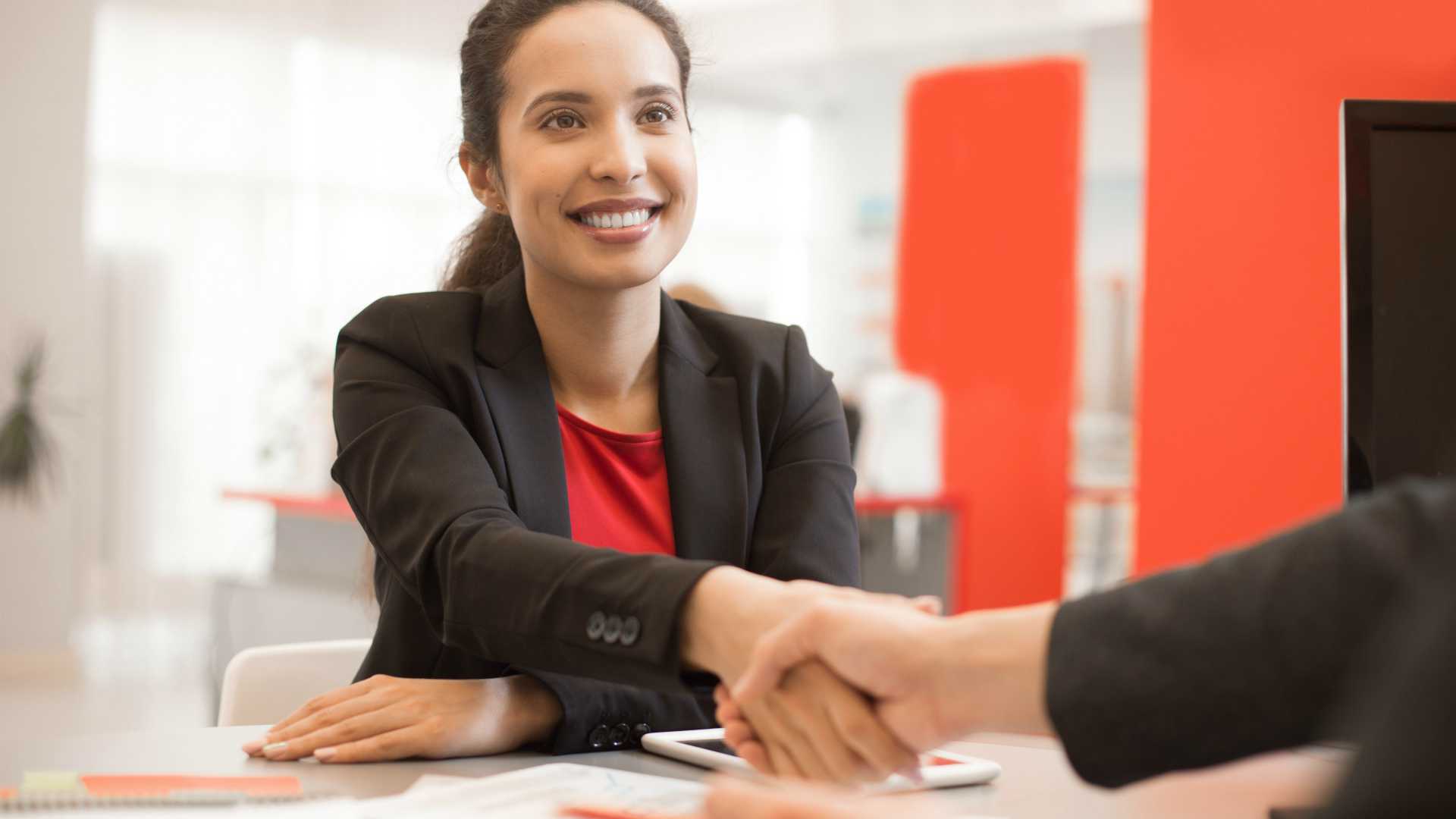 Young businesswoman shaking hands with colleague and accepting manager position