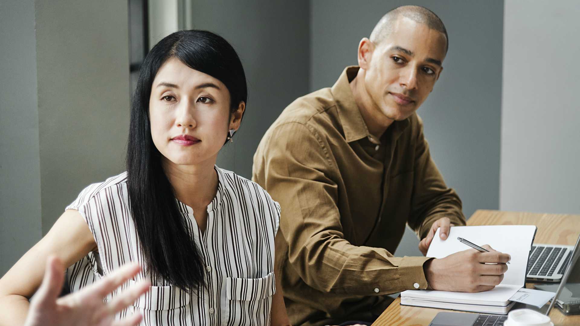 Businessman and businesswoman listening to colleague's proposed learning strategy