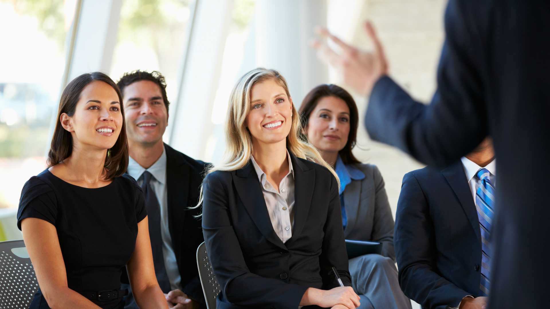 Group of engaged business professionals attentively listening to presentation