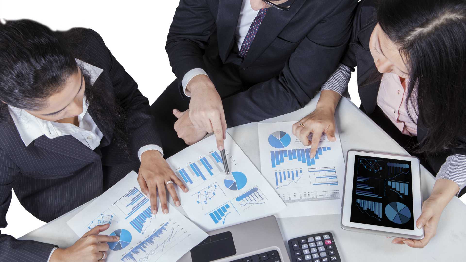 Aerial view of group of businesspeople gathered around conference table with tablets, graphs and data scattered around
