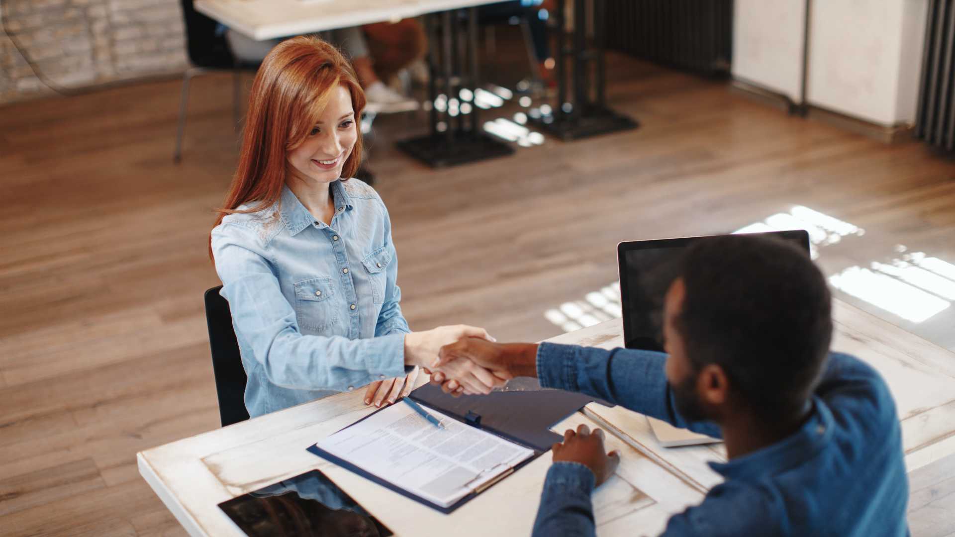 Young woman signing contracts and handshake with a manager