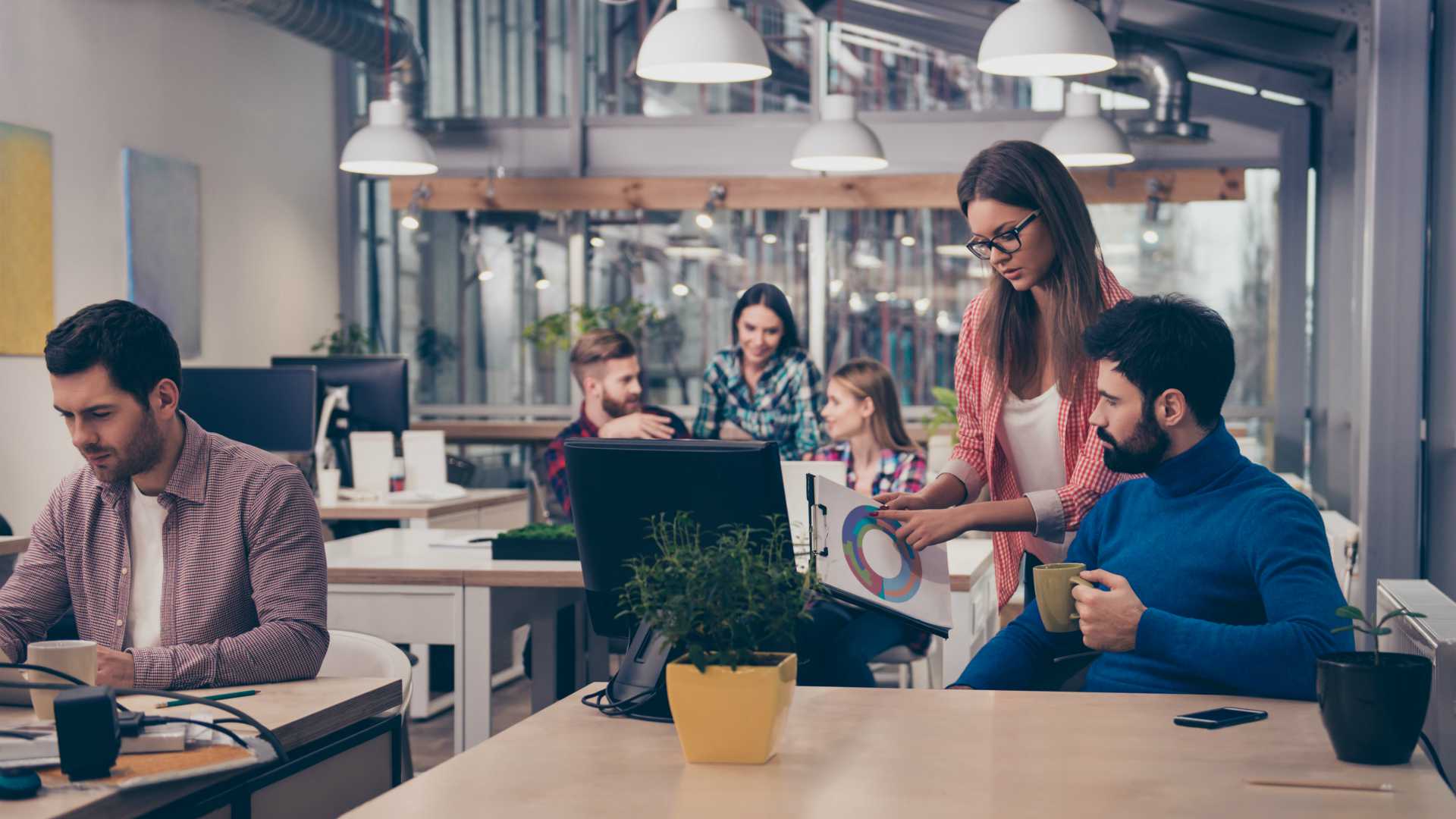 Young woman showing diagrama of growth to her colleague