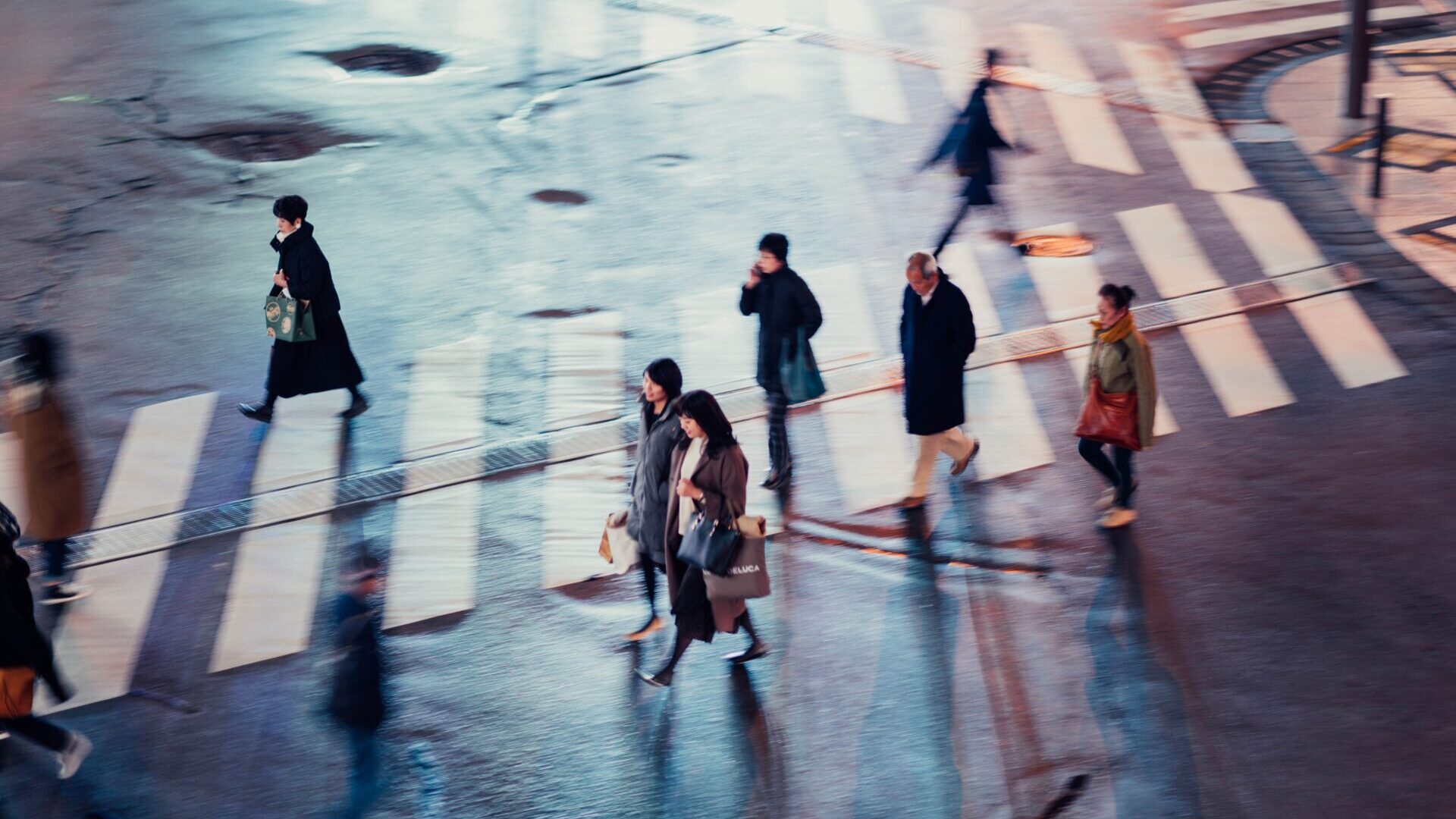 Aerial shot of busy crosswalk with pedestrians crossing