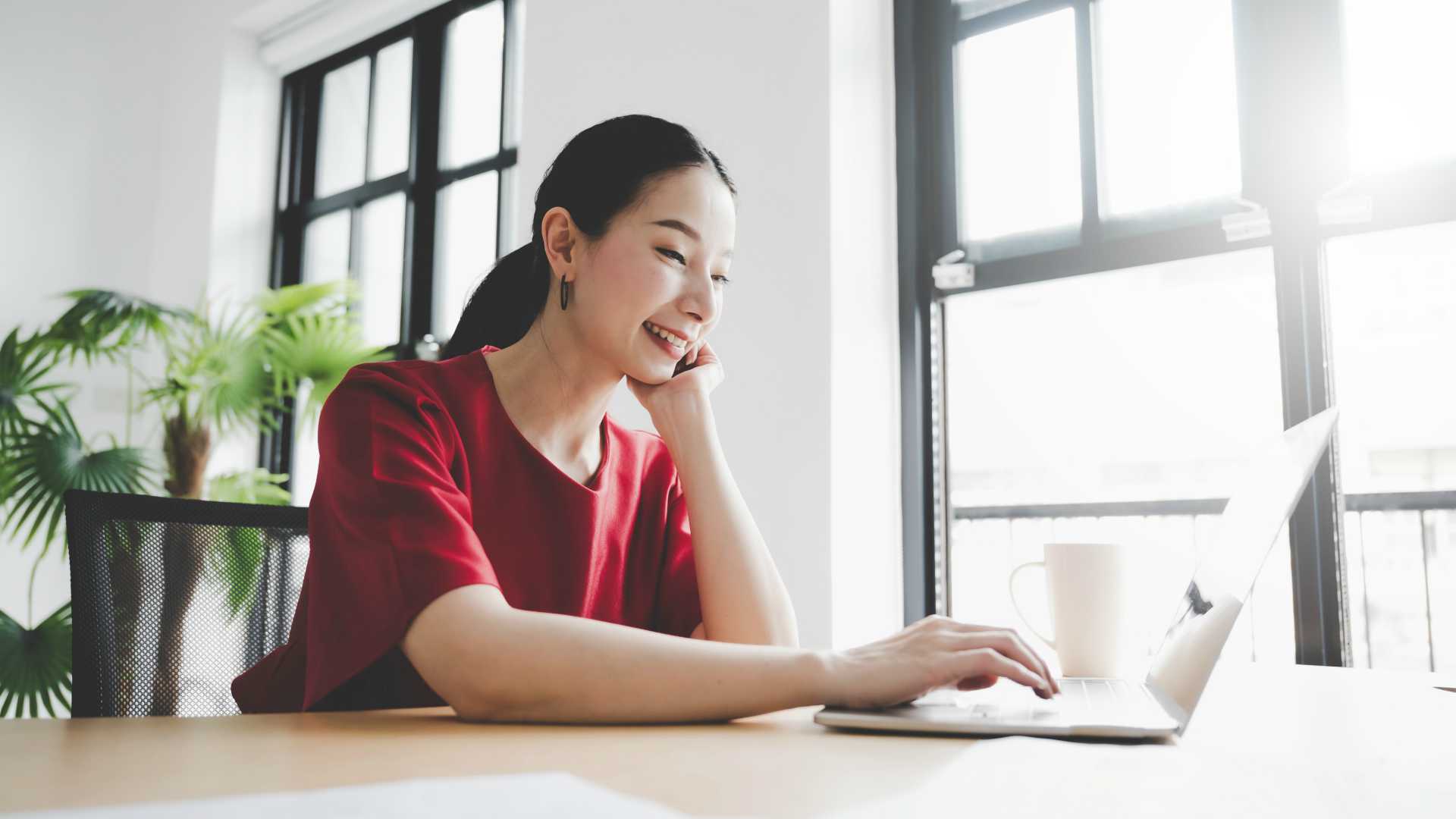 Portrait of young asian woman working on laptop in workplace