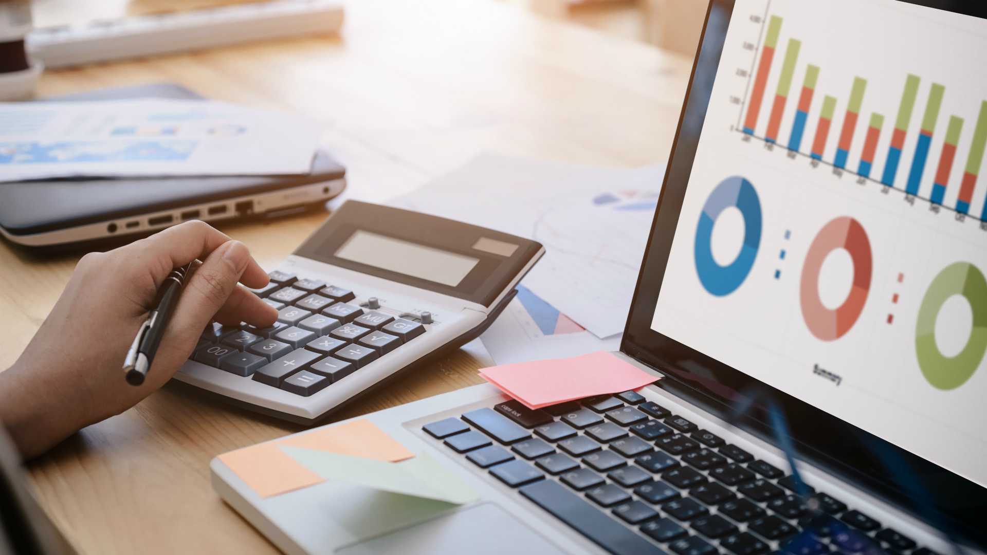 business woman uses a calculator to calculate the company's performance figures, graphs the monthly graphs for the meeting.