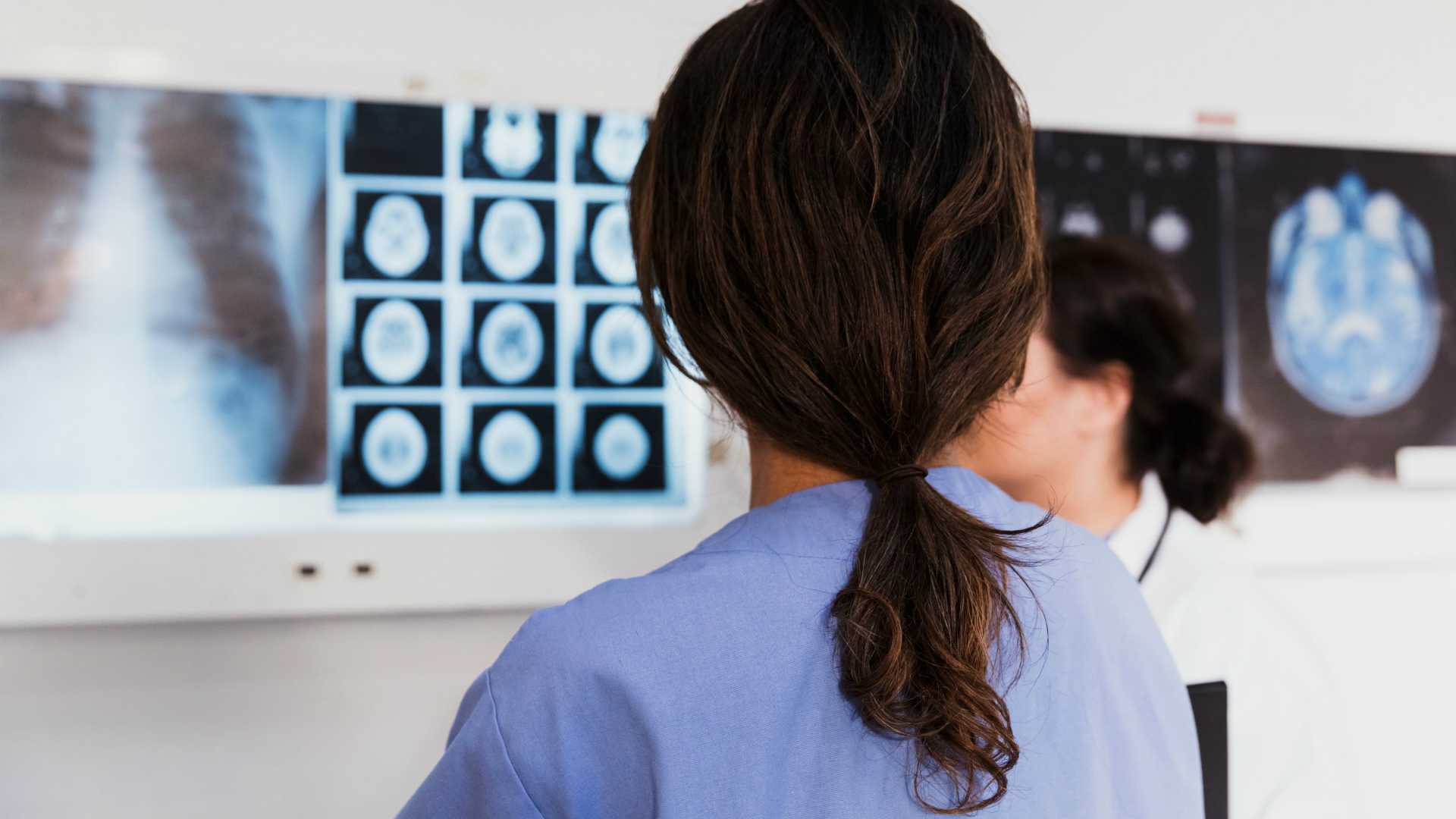 Brunette female medical worker examining brain scans