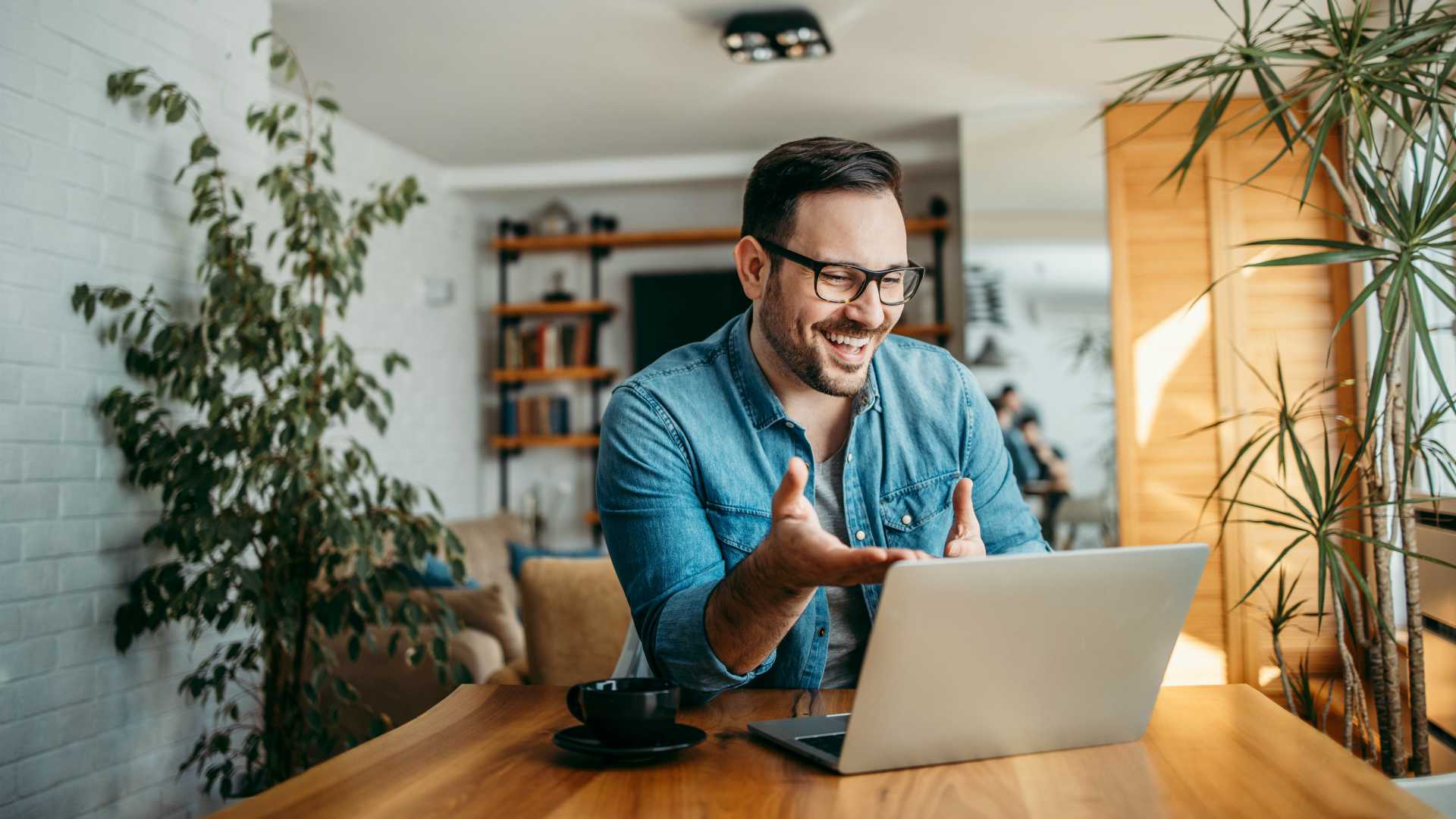 Portrait of a cheerful man having video call on laptop computer.