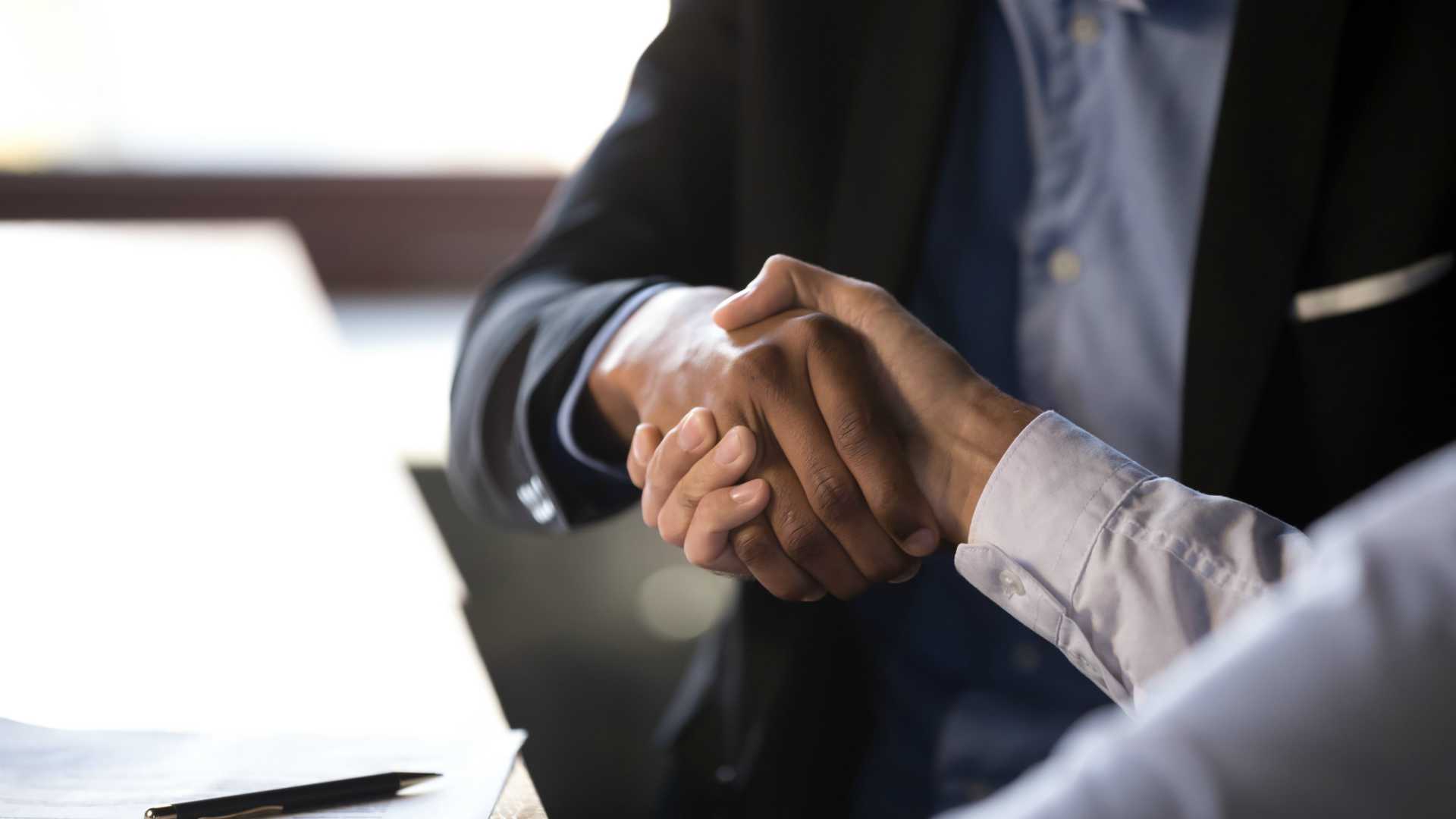 Close up african american businessman shaking hands with caucasian client.