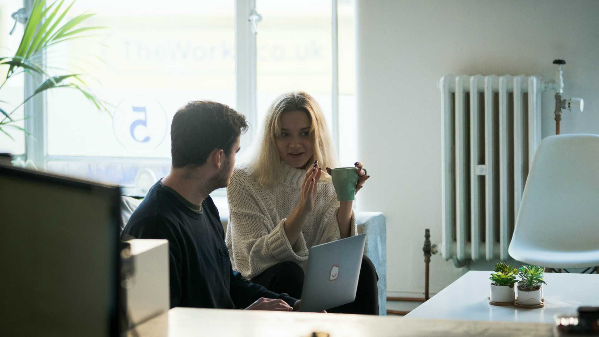 Female manager having coaching conversation with male employee in office