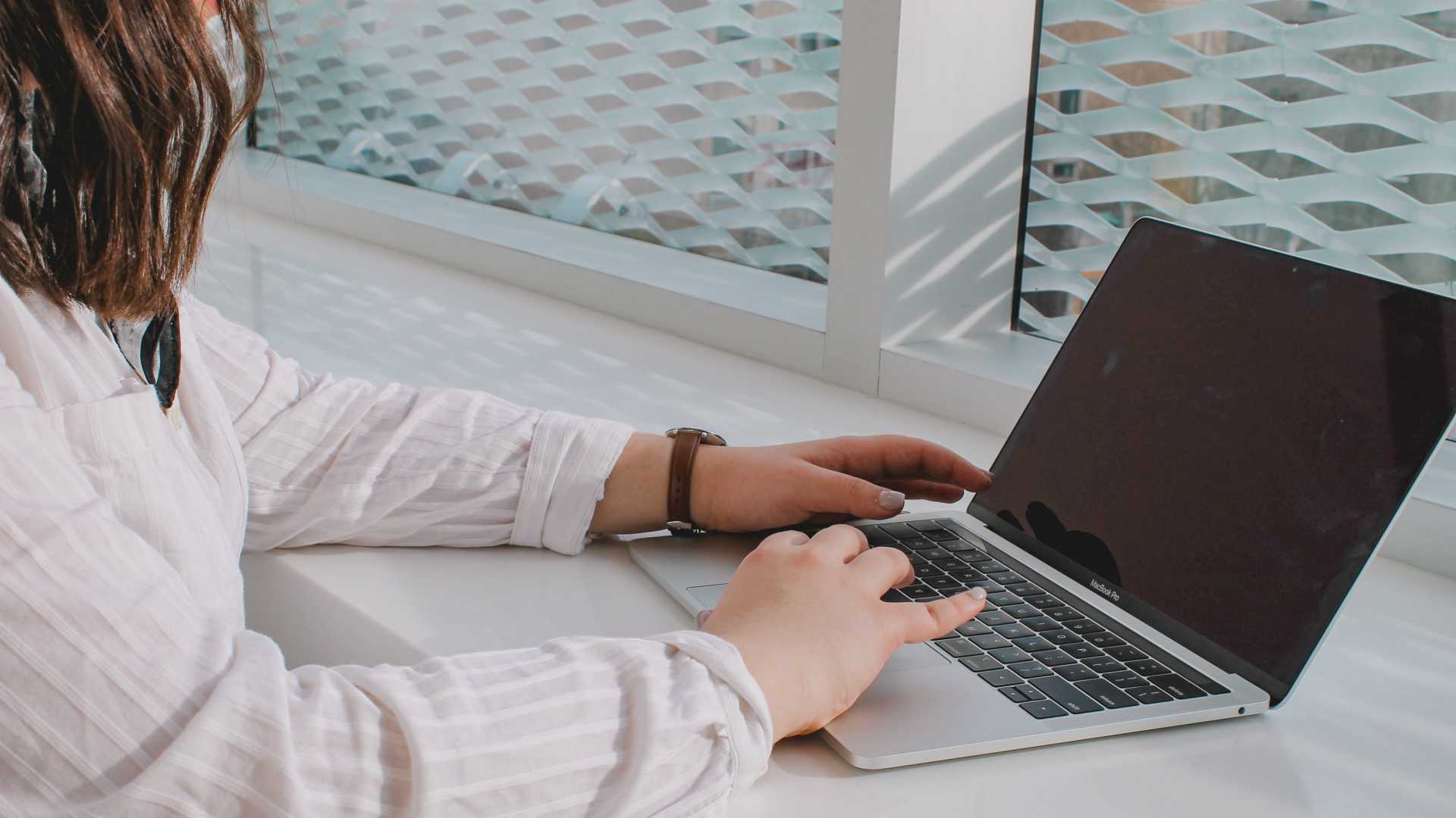 Over the shoulder shot of woman working on laptop