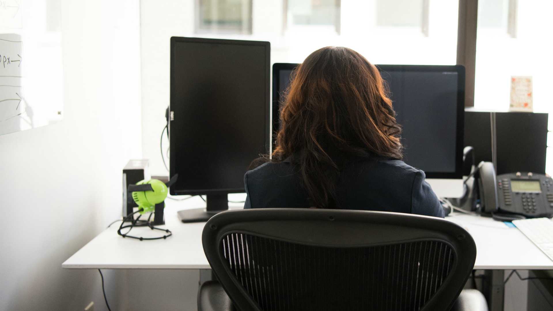 Saleswoman working at computer with back to camera
